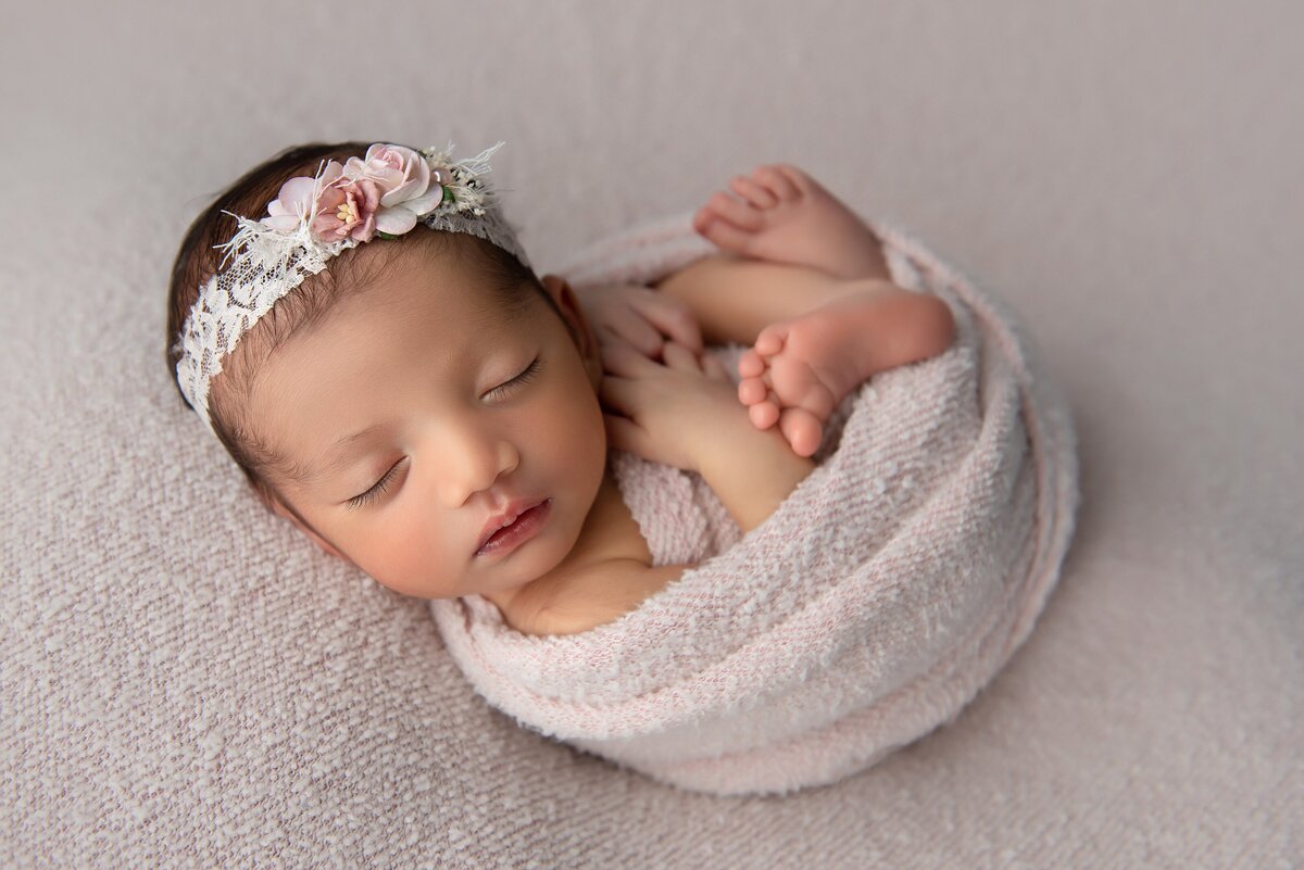 newborn baby girl in pink with flower headband