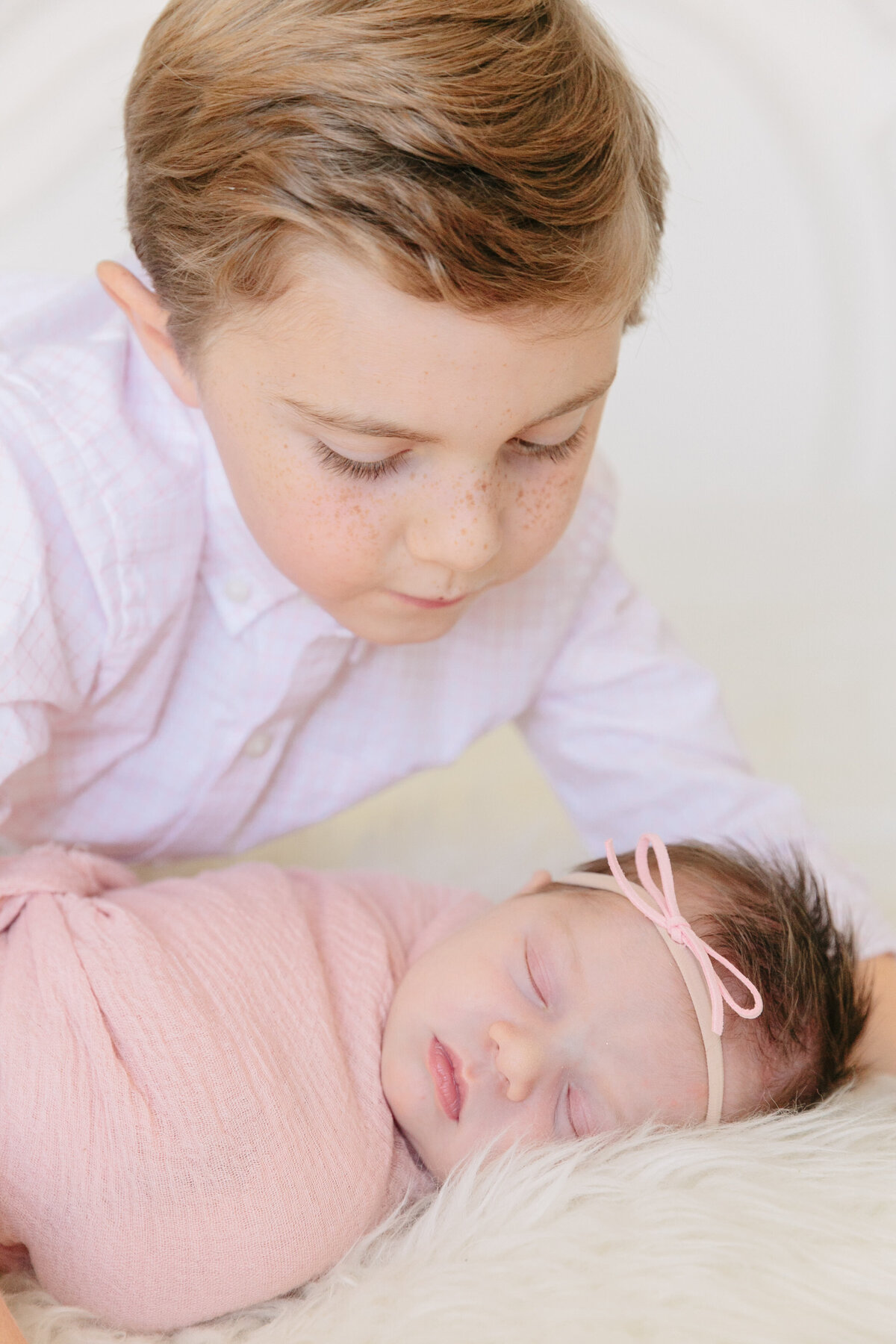 A young boy looking down at his newborn sibling