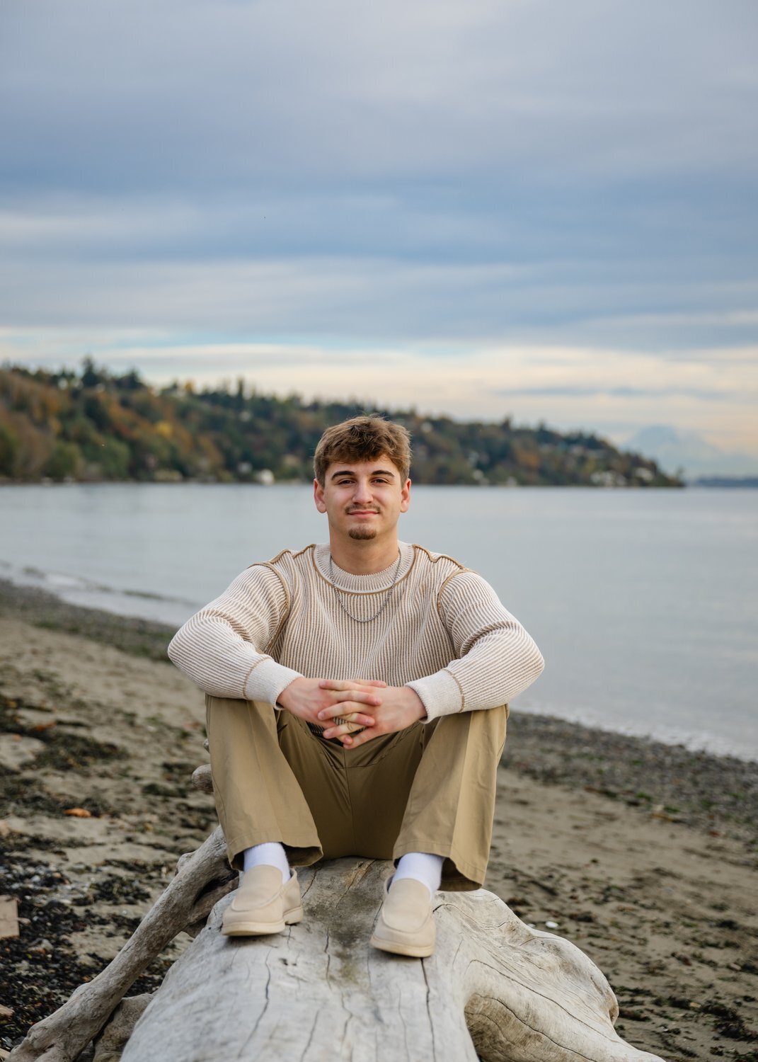 high school guy sitting on pnw beach