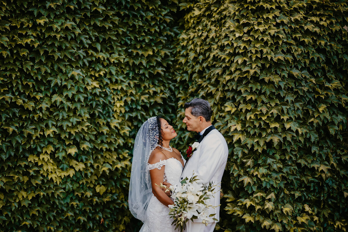 Bride and groom in front of an ivy-covered wall at Tenuta Corbinaia, romantic wedding in Tuscany.