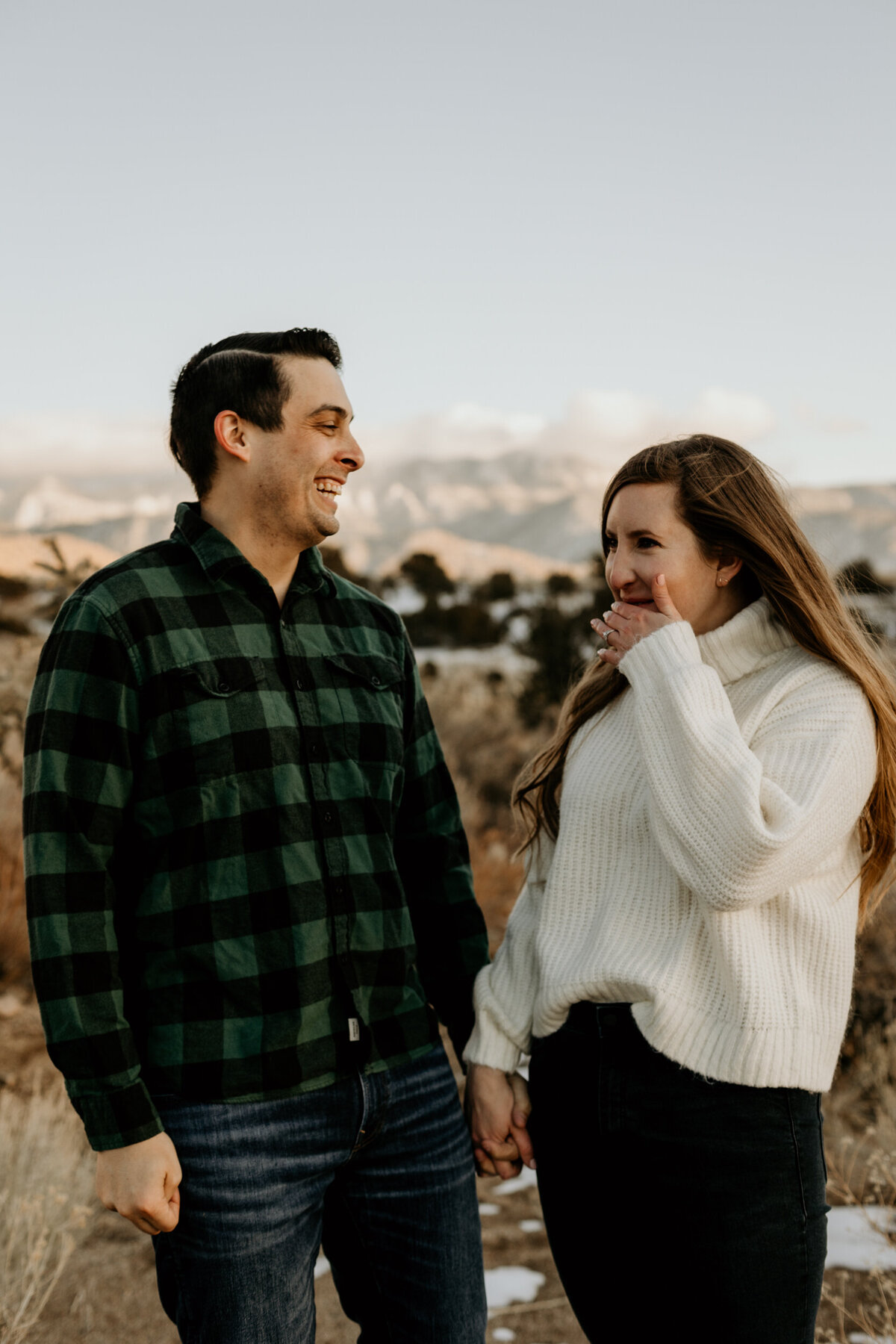 engaged couple laughing together in the desert