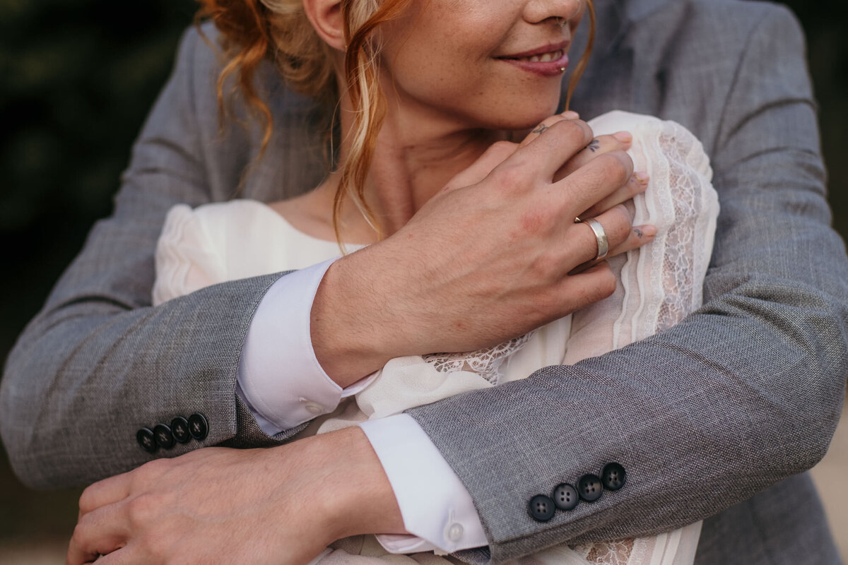 Bride and groom hold each other in a close embrace.