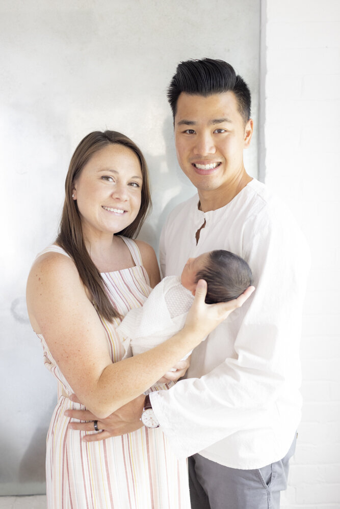 parents holding baby boy in portrait session with Rachel Girouard