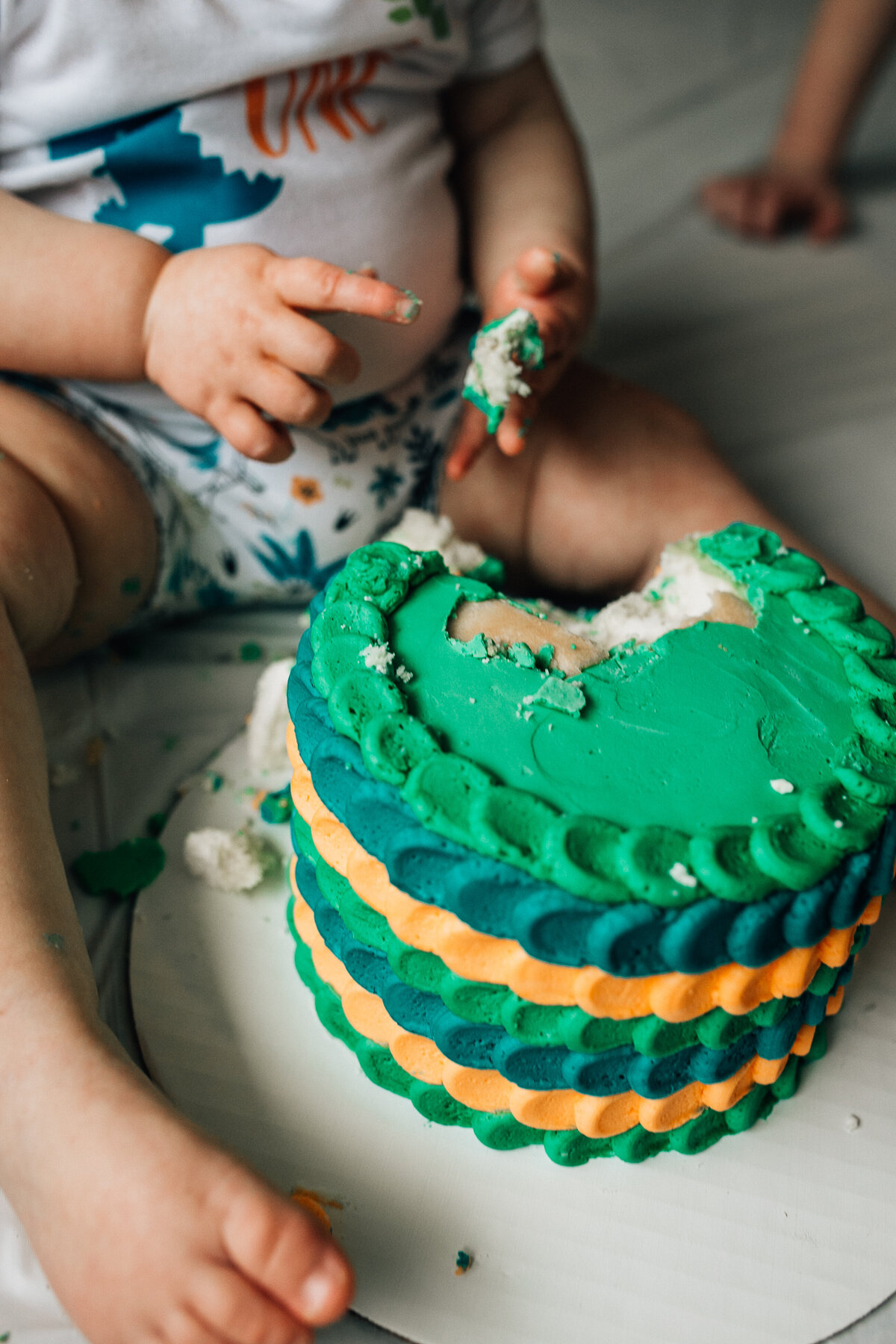 Baby sits on the floor with cake.