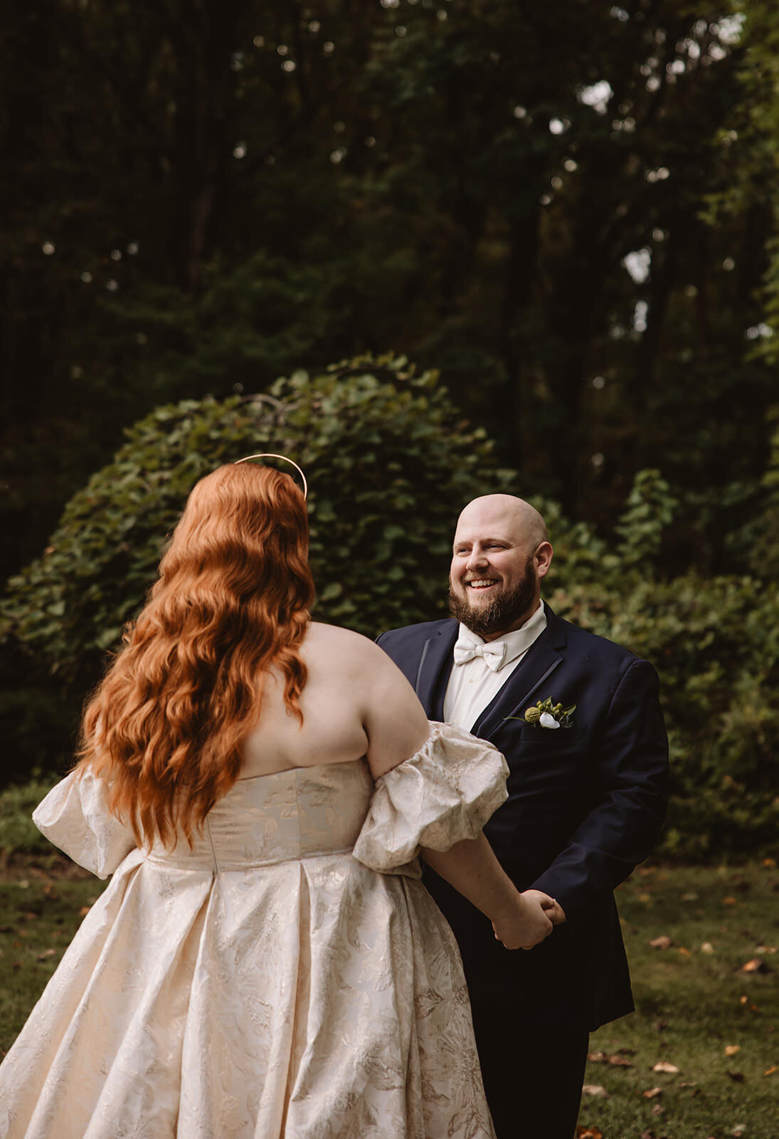Newlyweds holding hands and smiling at each other 