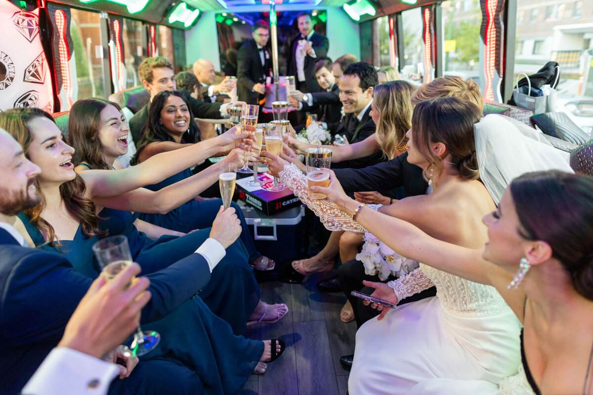 A group of people are toasting with champagne on a bus