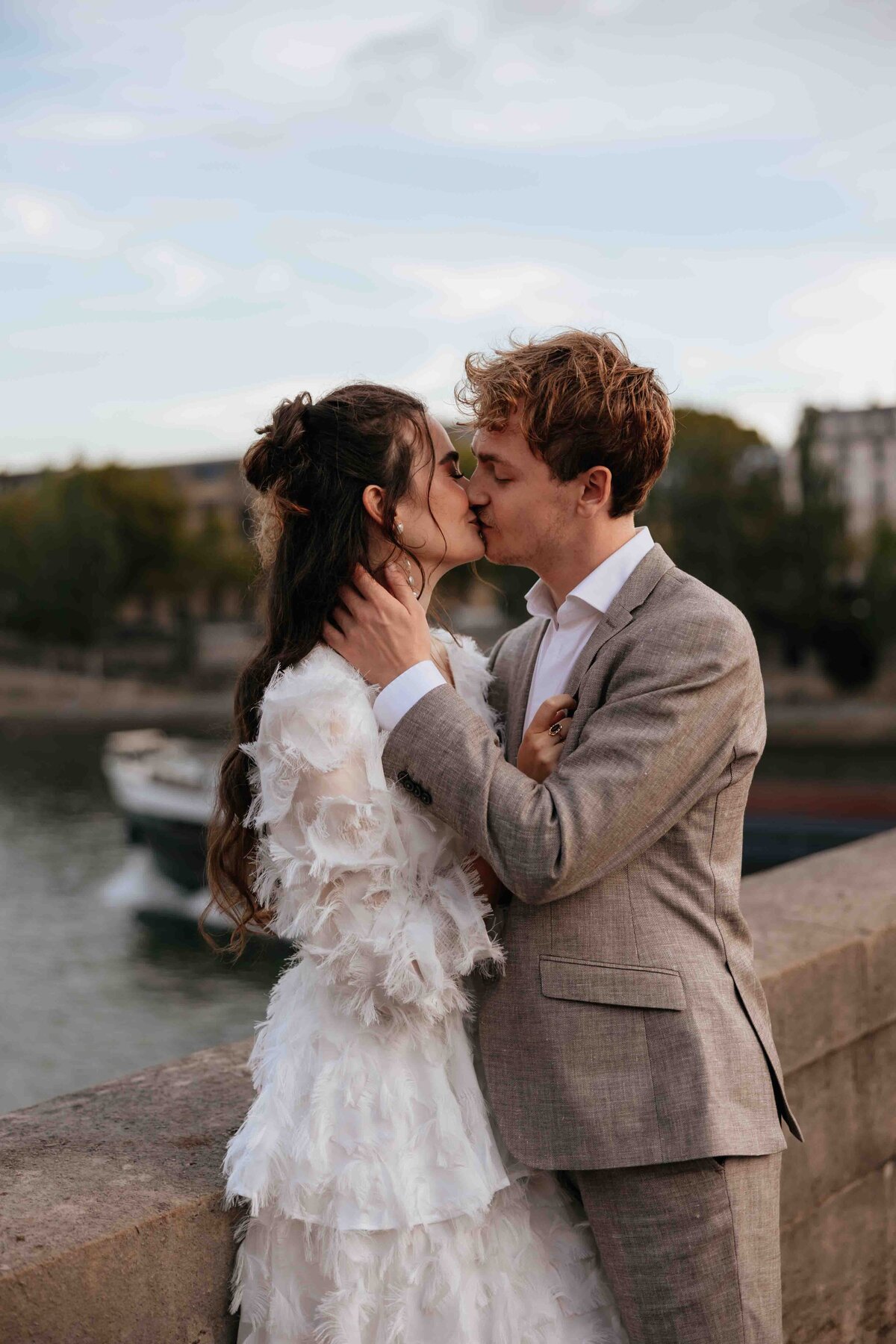 Professionele trouwfotografie in Parijs: een verliefd bruidspaar geniet van hun bruiloftsshoot bij de Seine.