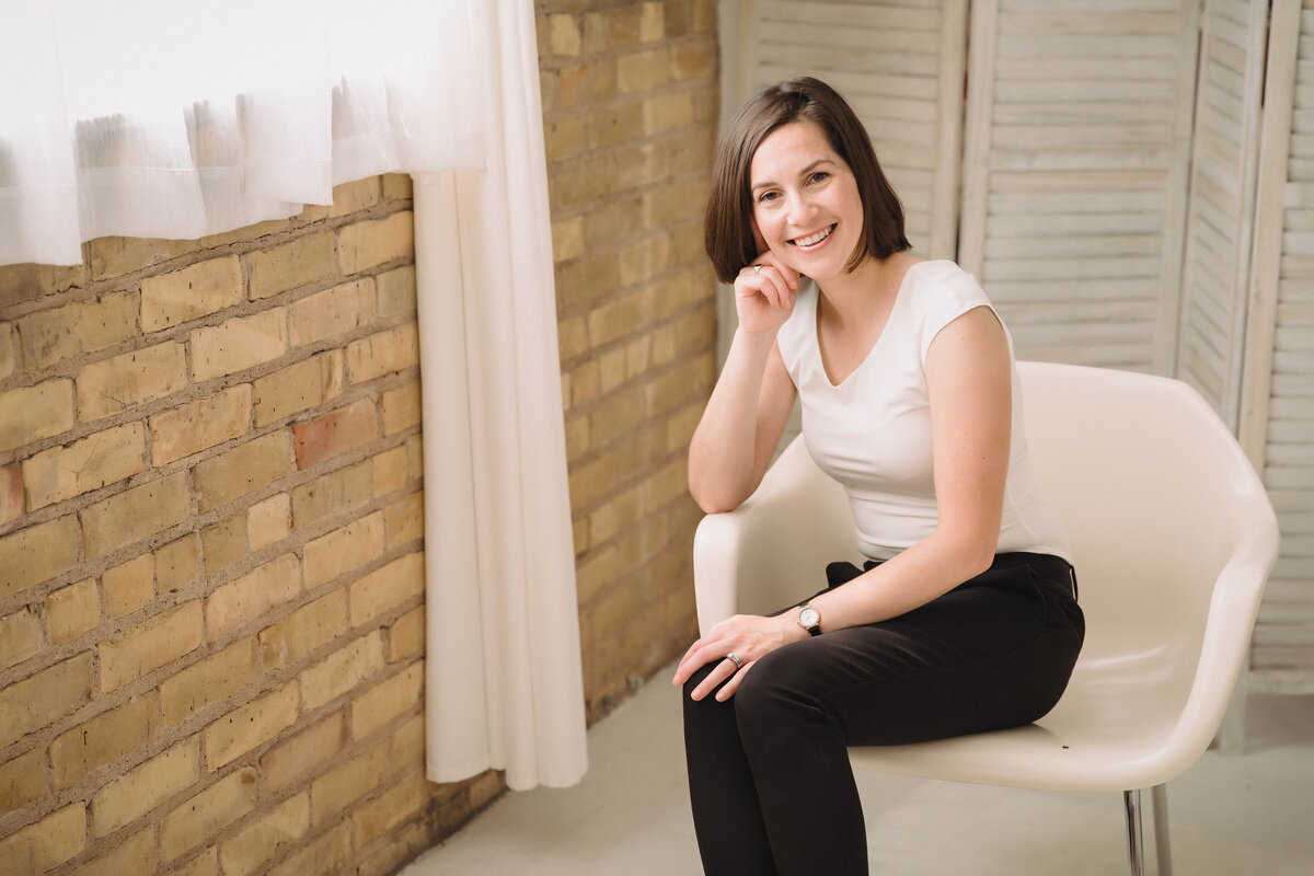 Sarah Weisbrod, Flutist & Teaching Artist, Sitting in a White Chair