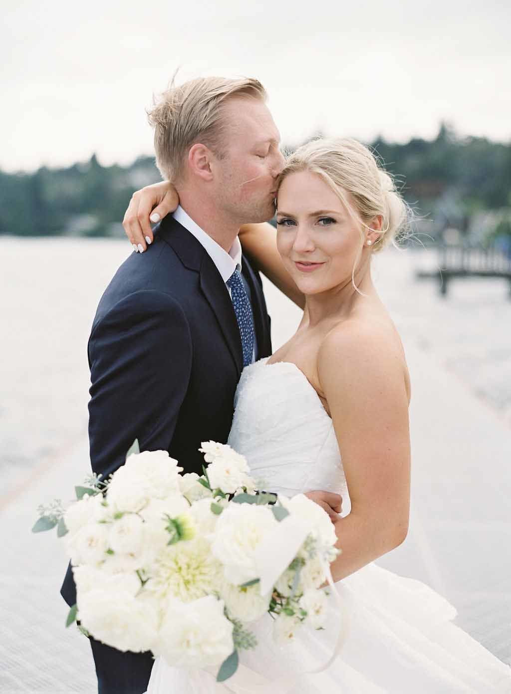 bride and groom at shores of Lake Washington with white bridal bouquet