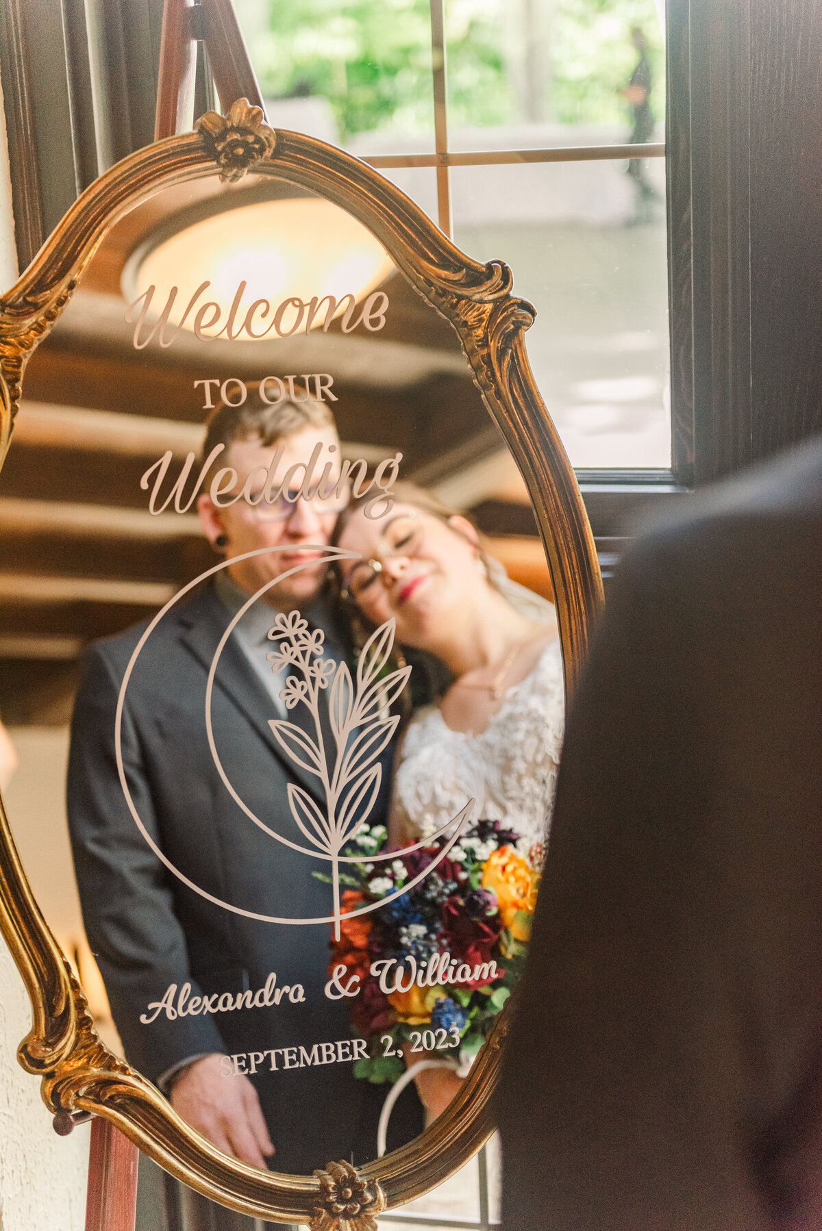 Bride and Groom posing in front of gold Decorative wedding mirror