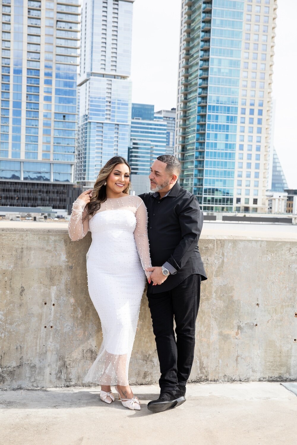 An Austin wedding photographer captures a beautiful photo of a bride and groom posing in front of a city skyline.