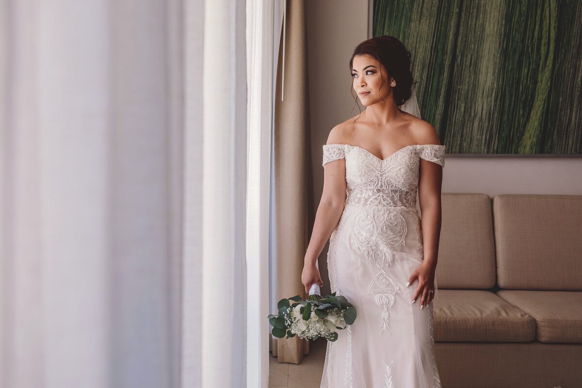 bride looking out window in at wedding in  Cancun