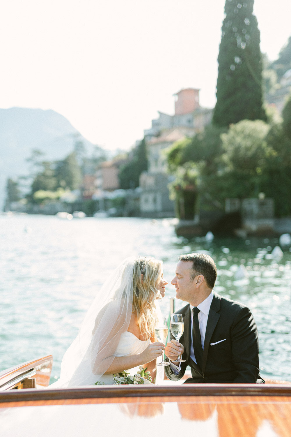 bride and groom kiss on a boat at lake como