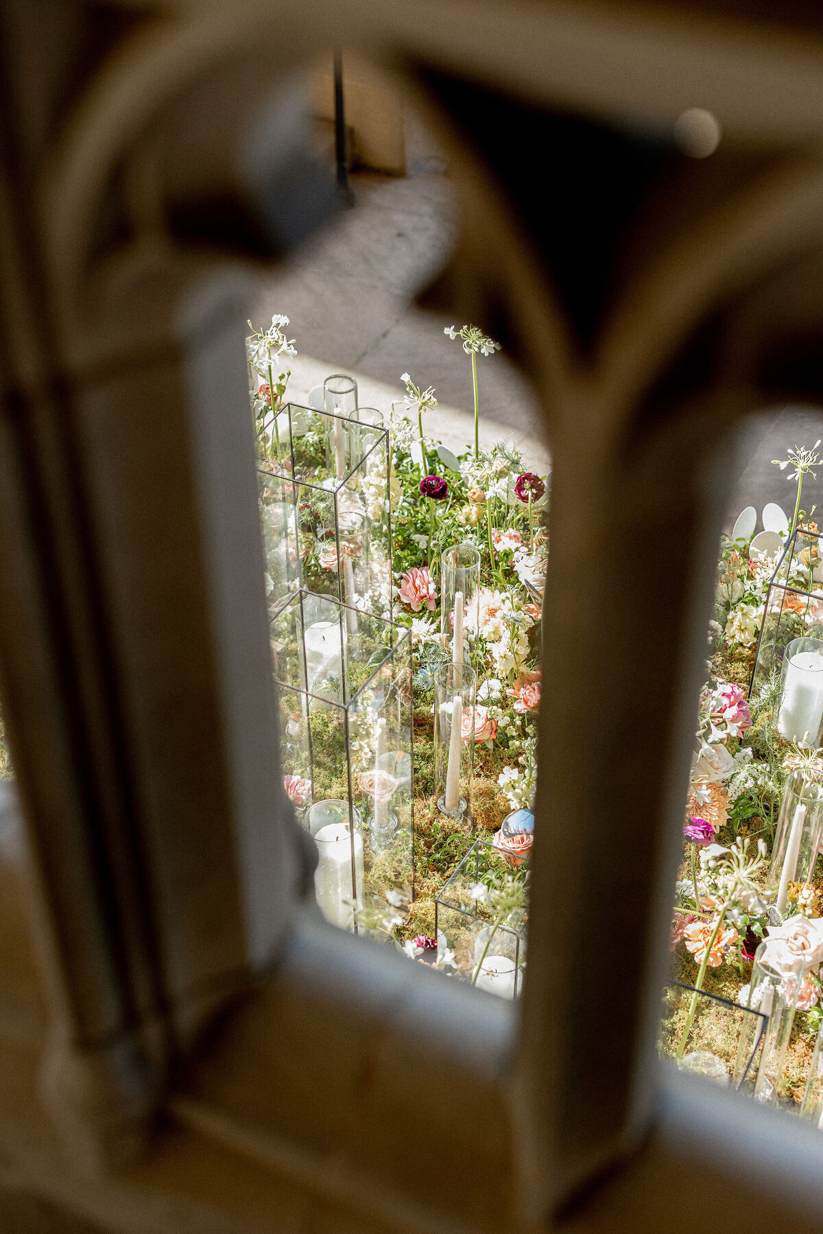 This captivating photo was taken at the Washington National Cathedral in Washington D.C. by the talented photographer Twah Dougherty. The view through ornate stonework unveils an intricate floral display featuring a variety of colorful flowers, verdant greenery, and delicate glass elements. The lush arrangement appears carefully curated, enhancing the natural beauty of the Cathedral's surroundings. Current Films also captured this stunning scene as videographers, adding another dimension to the visual storytelling.