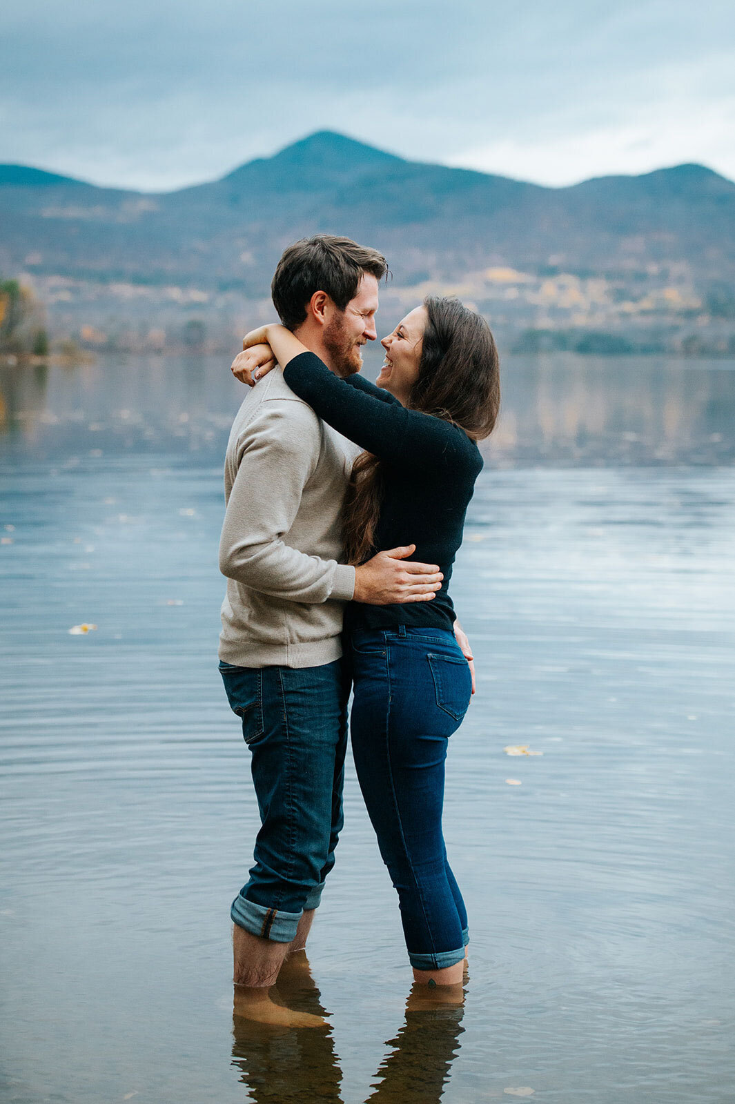 engaged couple standing in water at chittenden reservoir in the fall