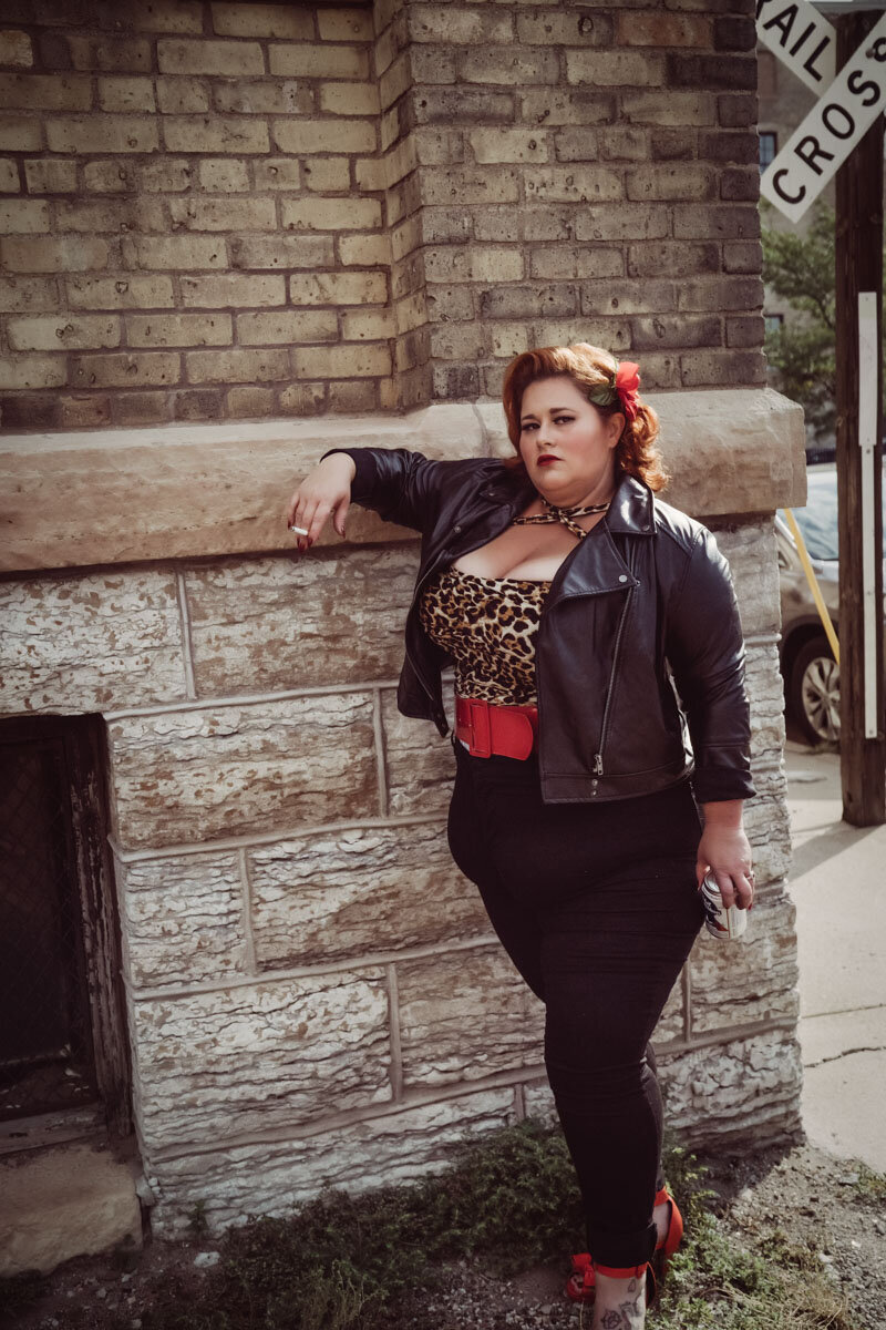 Vintage outdoor pinup  curvy girl in Minneapolis Mn wearing leopard top and leather jacket smoking