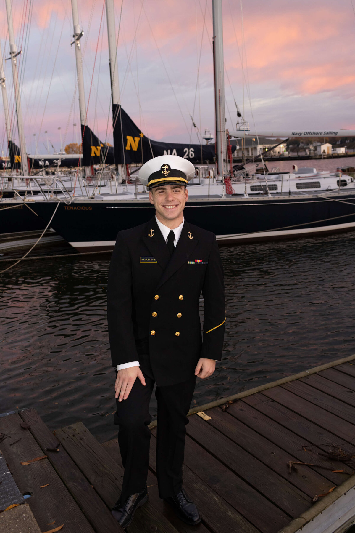 USNA Midshipman in dress blues at sunset on the pier in the Santee Basin at US Naval Academy.