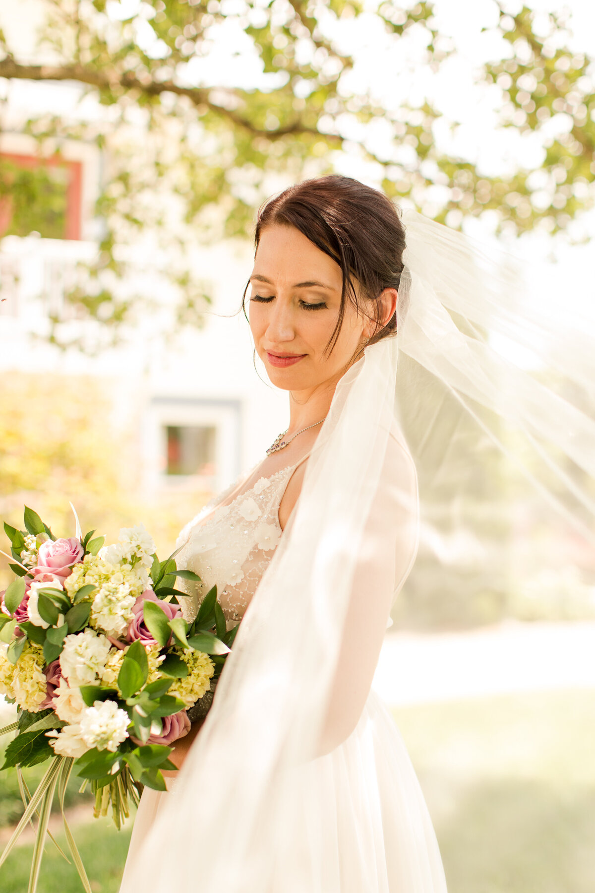 bride with veil holding flowers