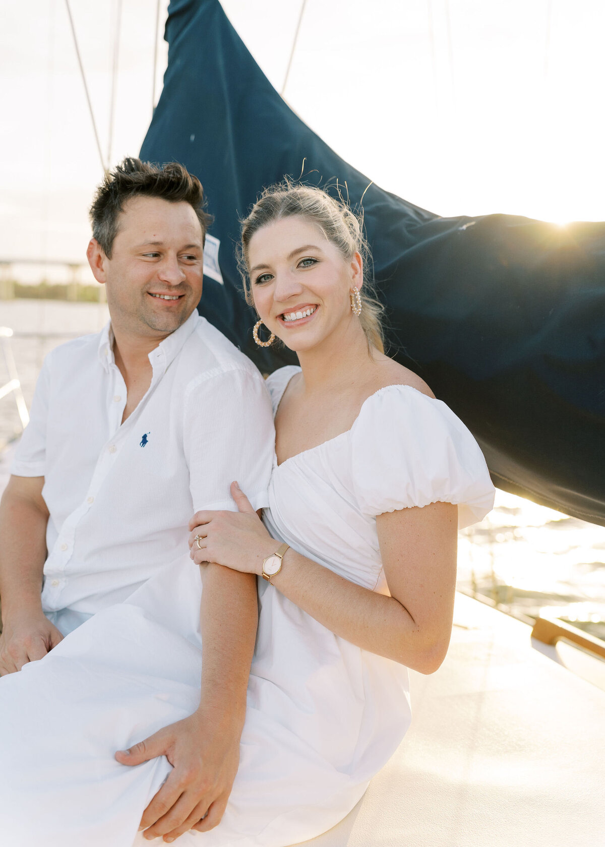 woman holding on to her fiance while on a sailboat