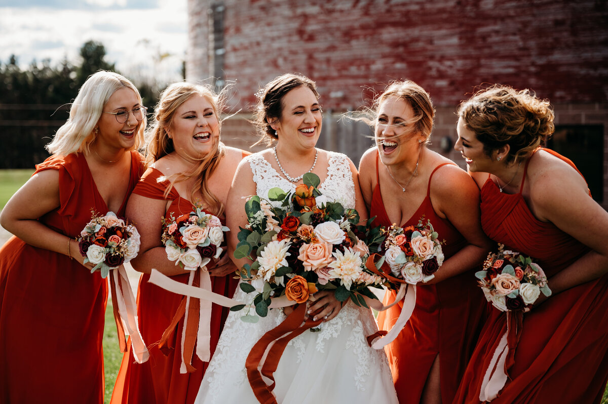 Bride and bridesmaids laughing at each other