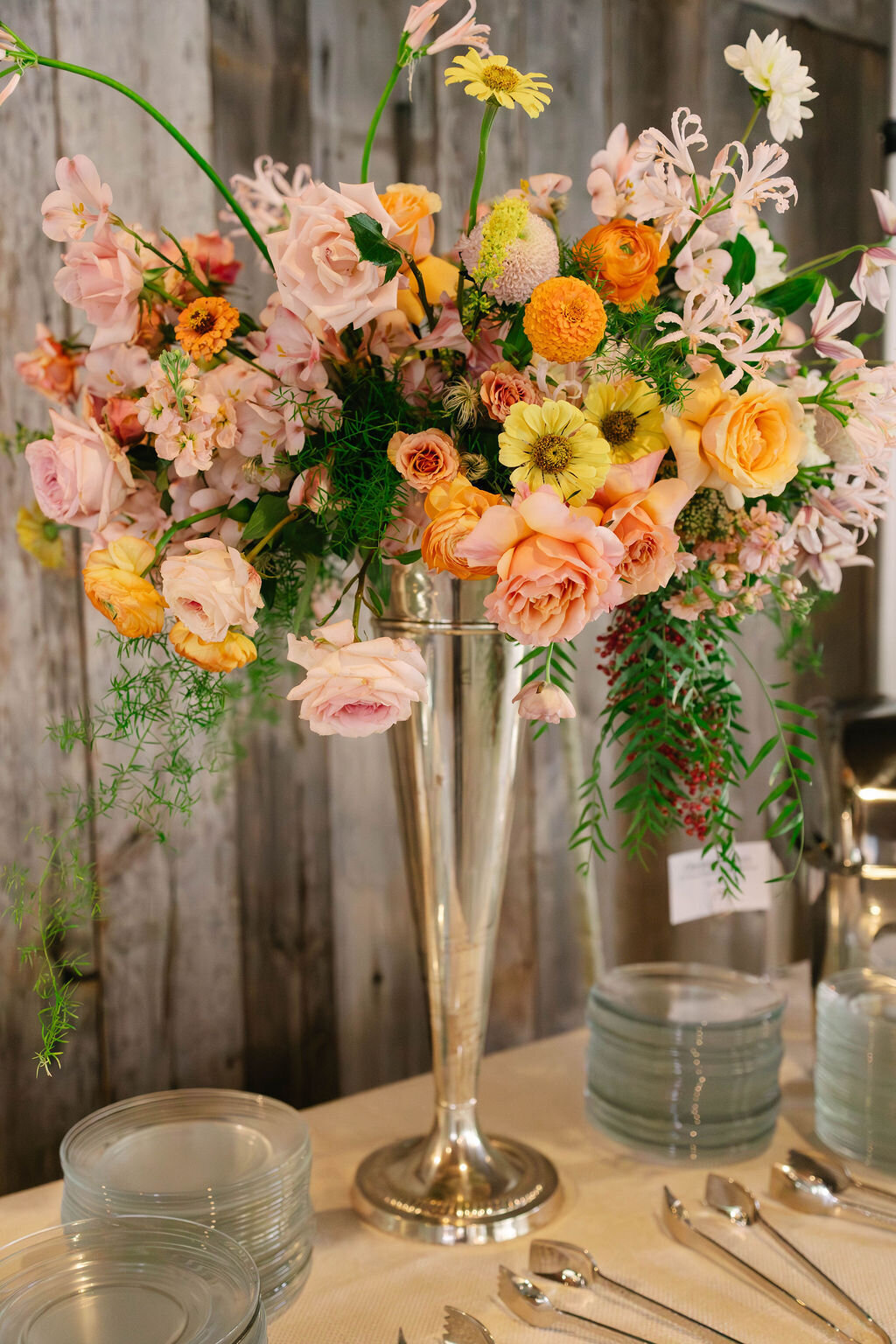 Tall pastel floral arrangement featuring roses and ranunculus at the Bascom Center fall wedding reception in Highlands NC.