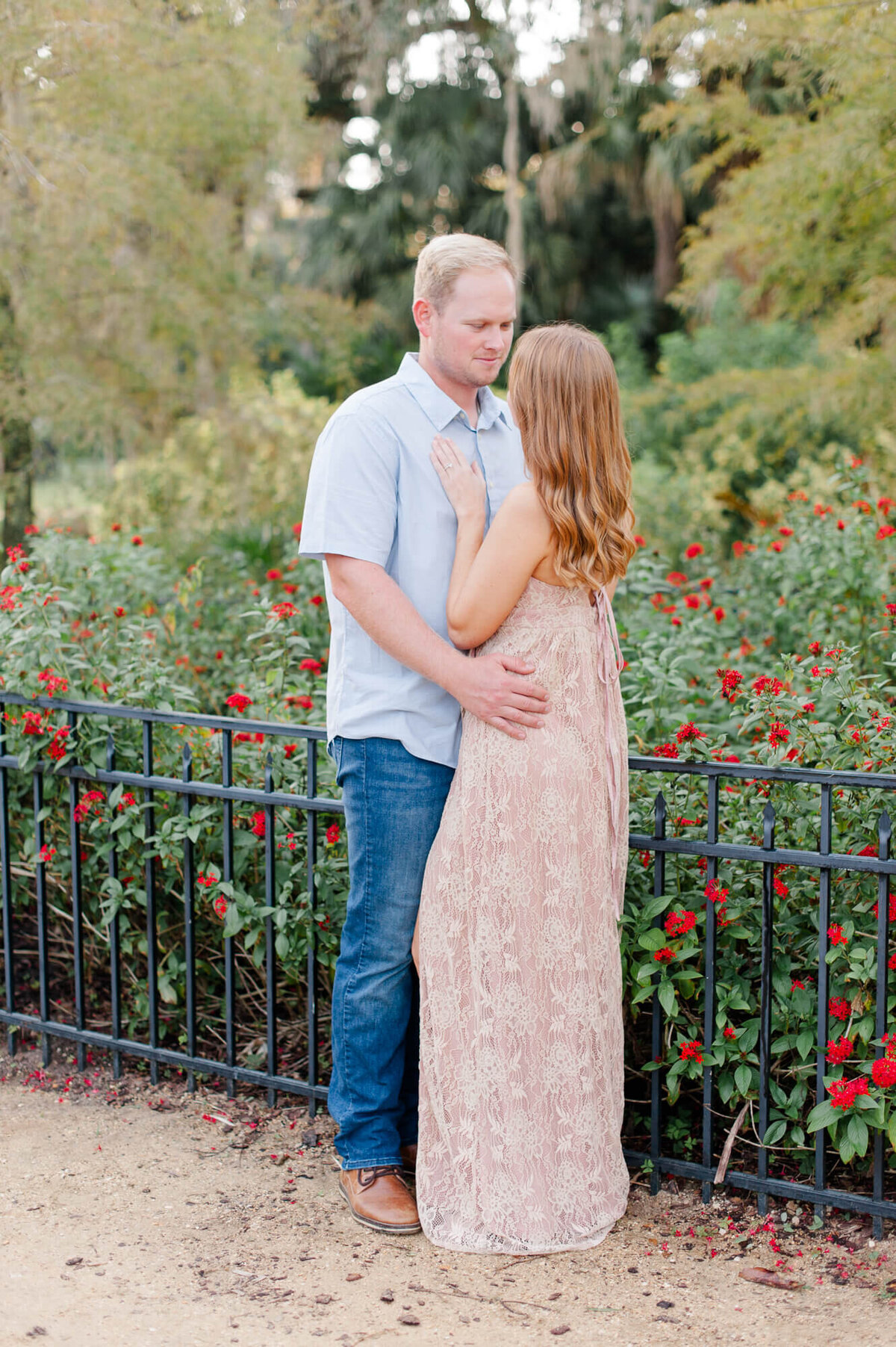 Young couple stands near a garden during their photoshoot with Orlando photographer