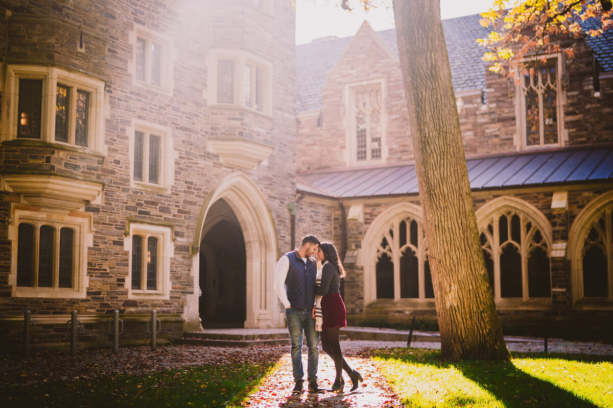 An engagement couple share moment during the fall in princeton university during golden hour in nj