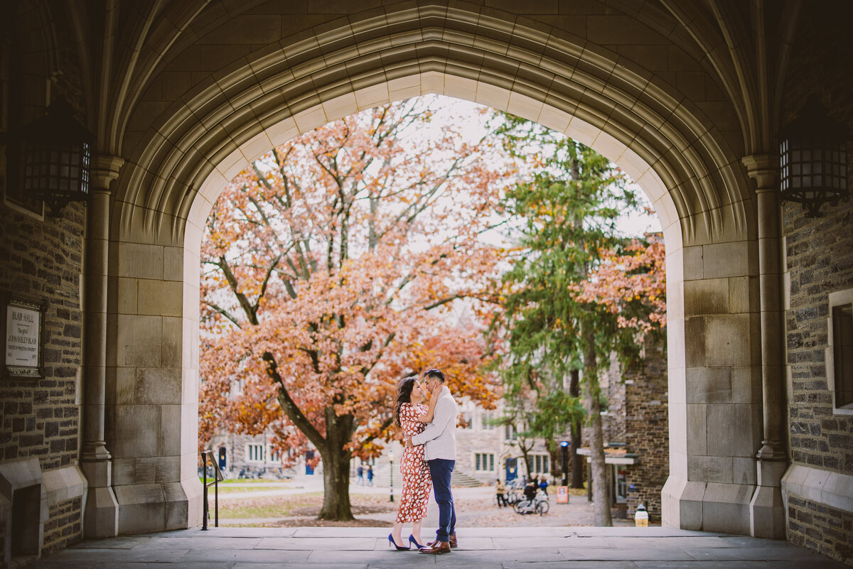 A couple share a moment during their engagement session under the arch at princeton university