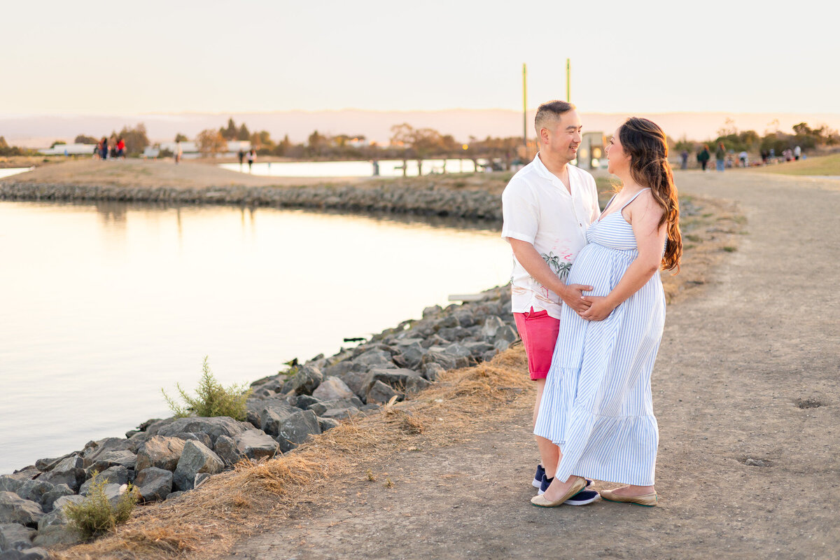 Expecting couple standing by the rocks with water and sunset in the background — Bay Area Maternity Portfolio - Ellobelle Photography Family Photographer