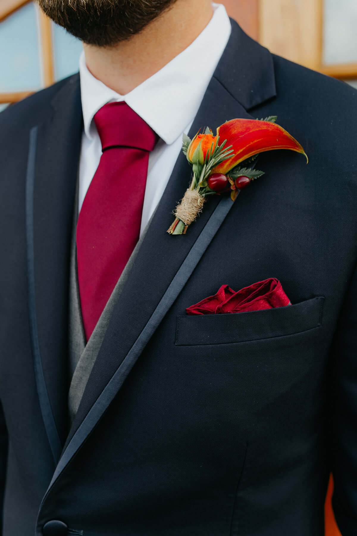Groom wearing fall themed boutonierre with a calla lily and wrapped in  jute twine