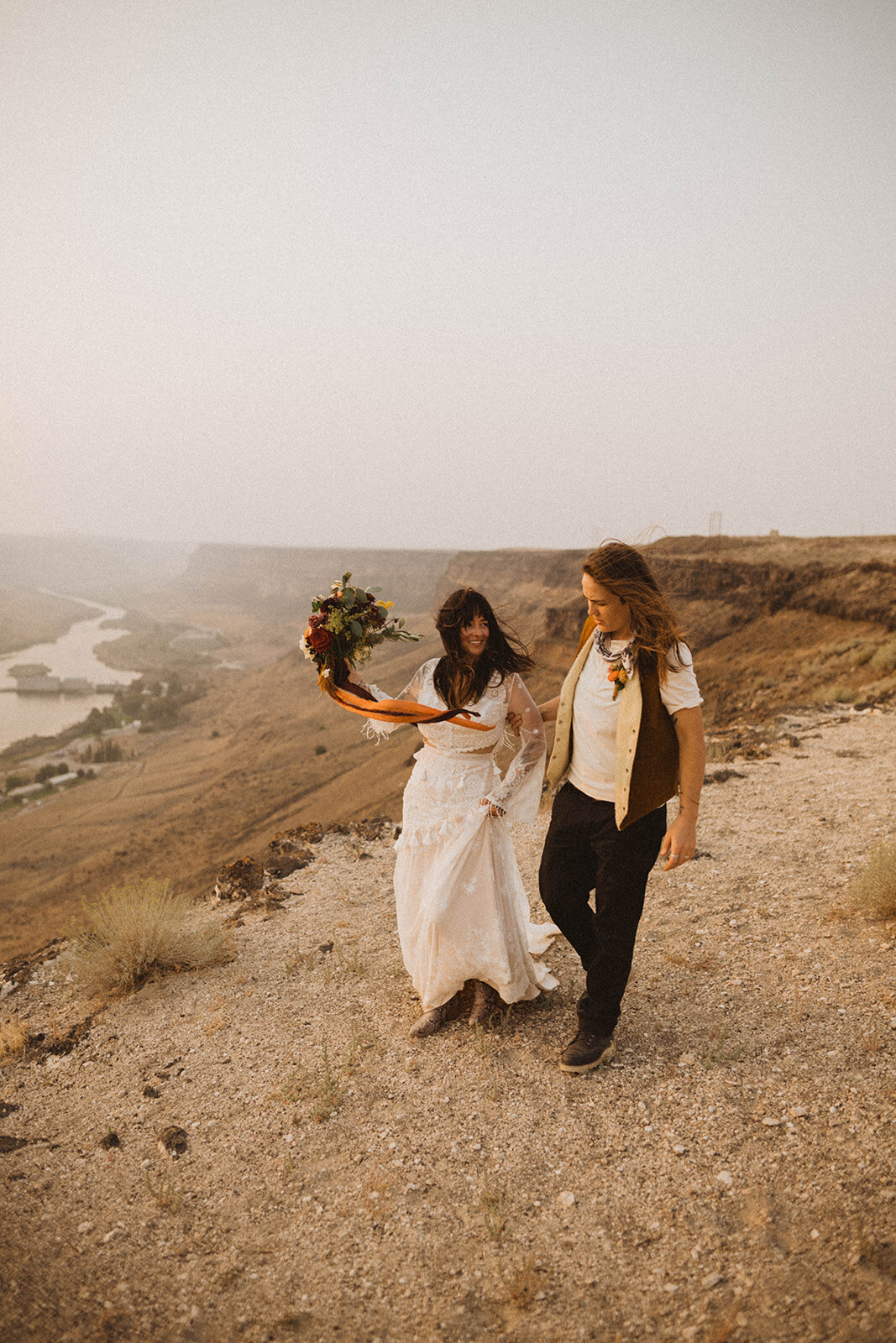 lgbtq elopement in the pnw brides stand on the rim of the snake river during their elopement