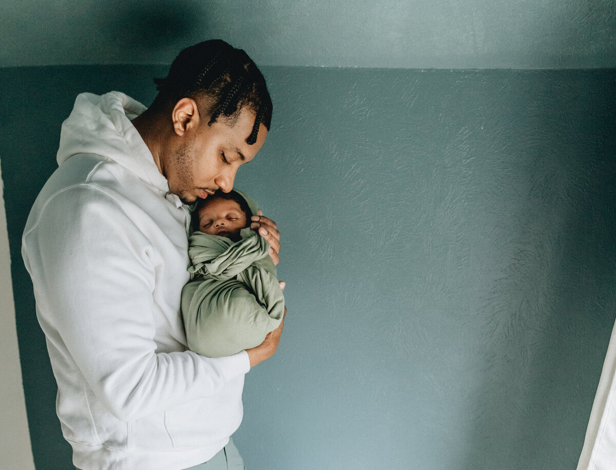 Family photography of dad holding newborn baby
