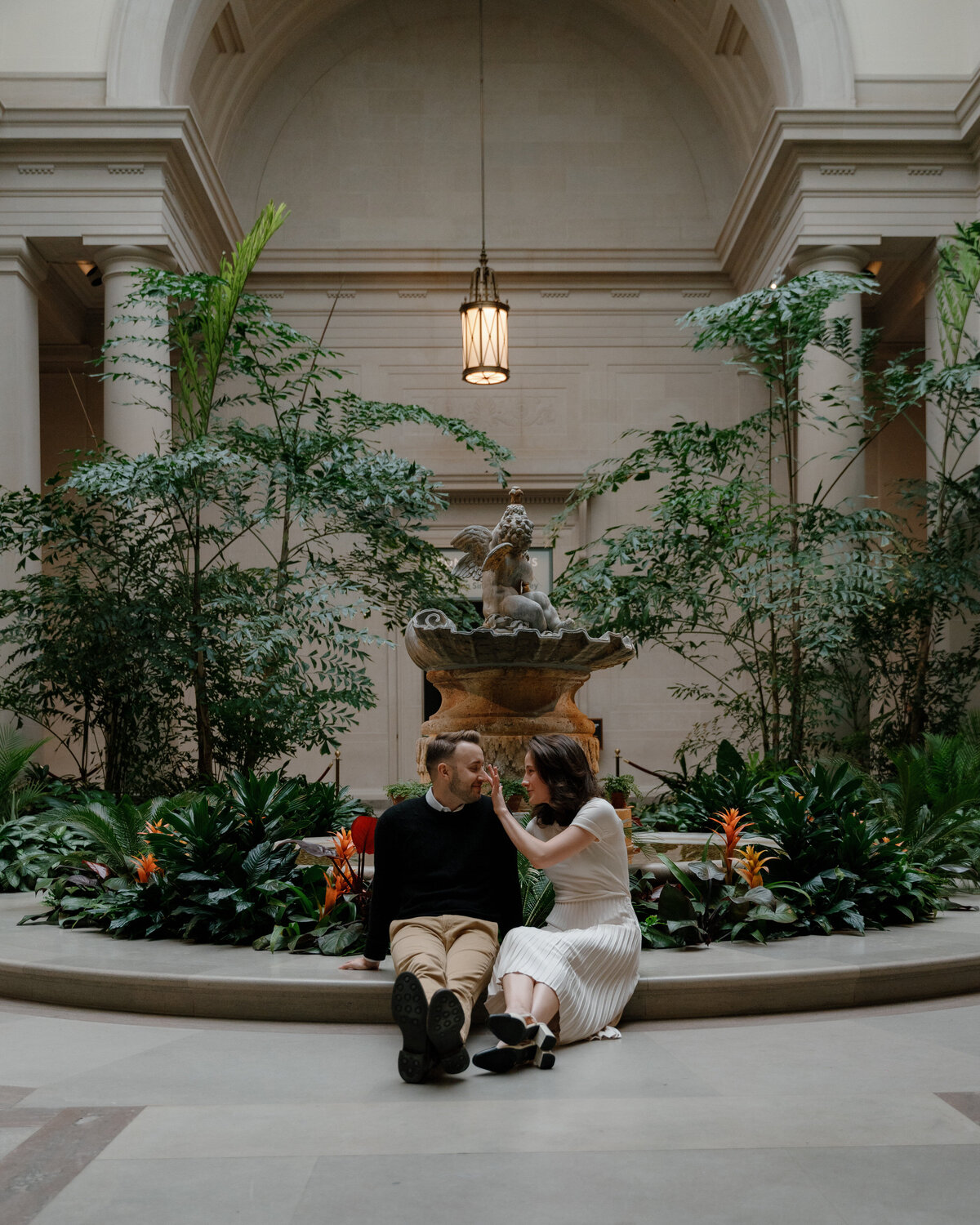 A couple sitting in a small garden alcove together