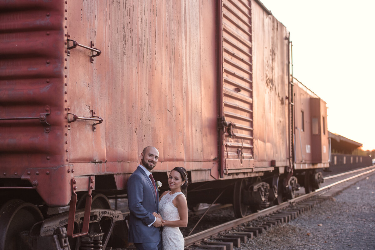 bride and groom posing by a cargo train at Maritime Parc