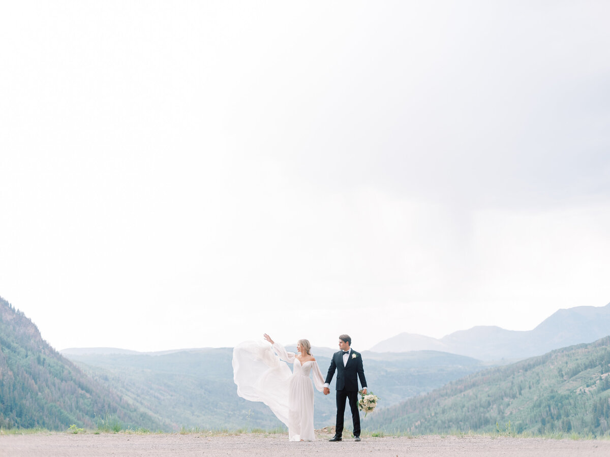 Romantic portrait of bride and groom looking out over mountain views in Boulder Colorado.