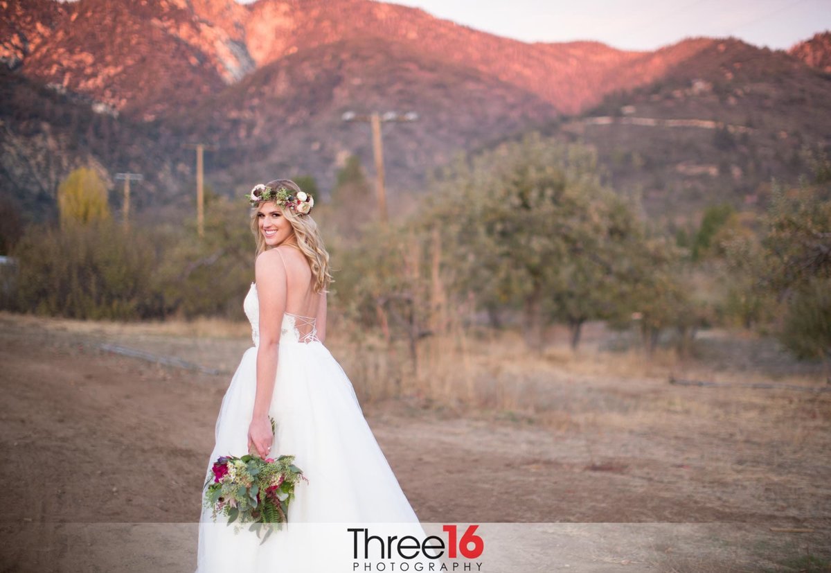 Bride poses for the camera with the hills in the background at Riley's Farm