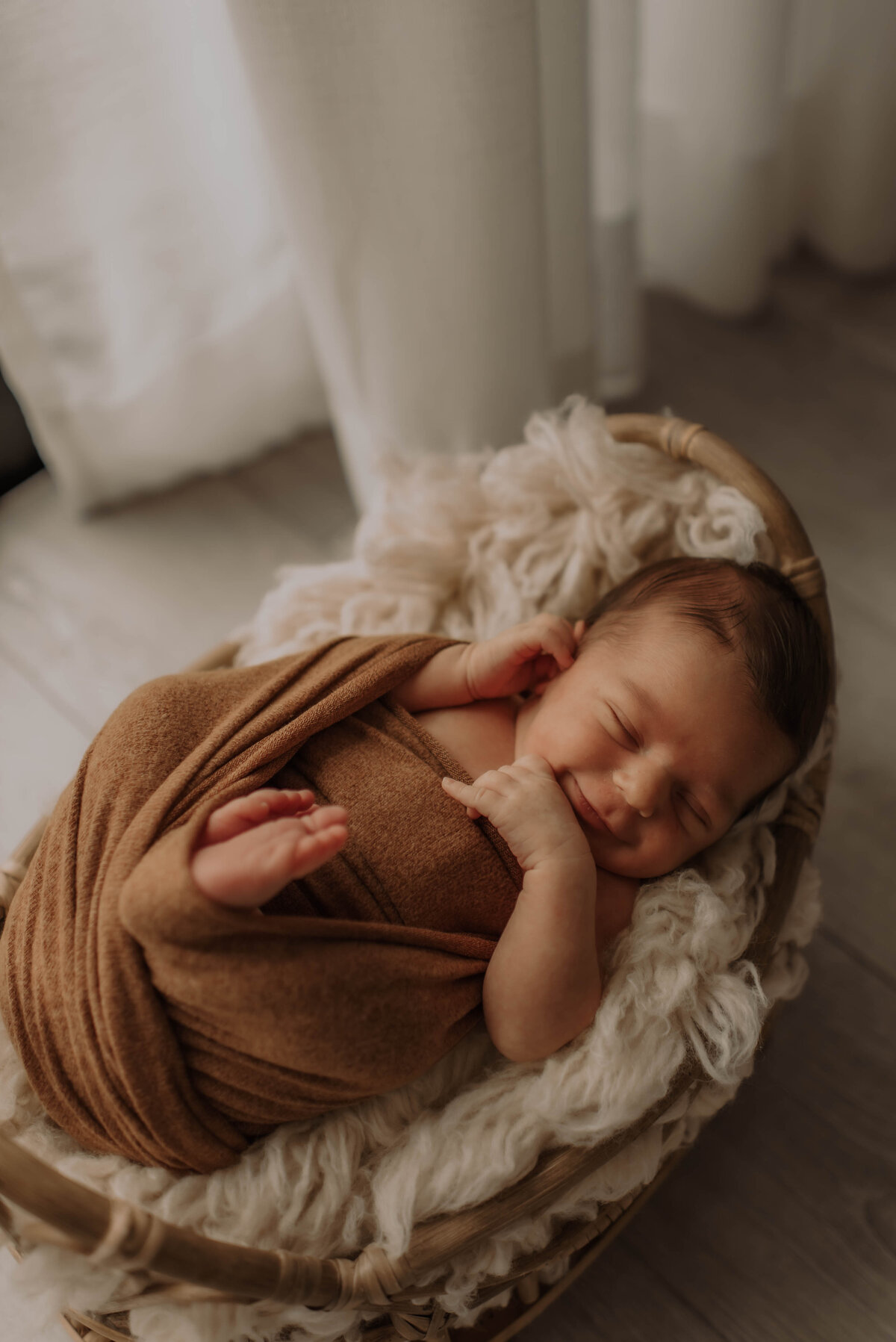 Baby slaapt in mandje tijdens newborn fotoshoot