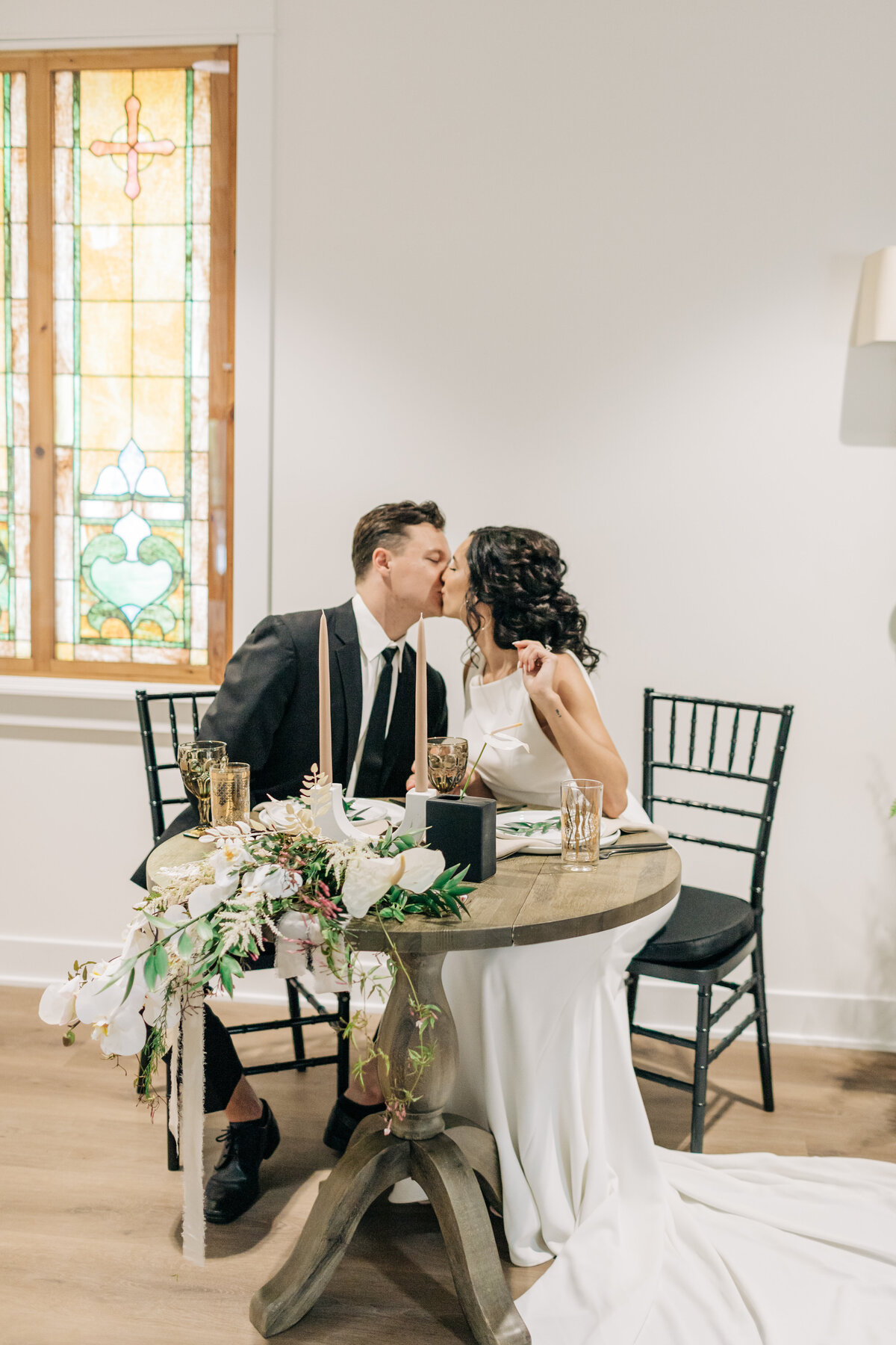 bride and groom kissing at table