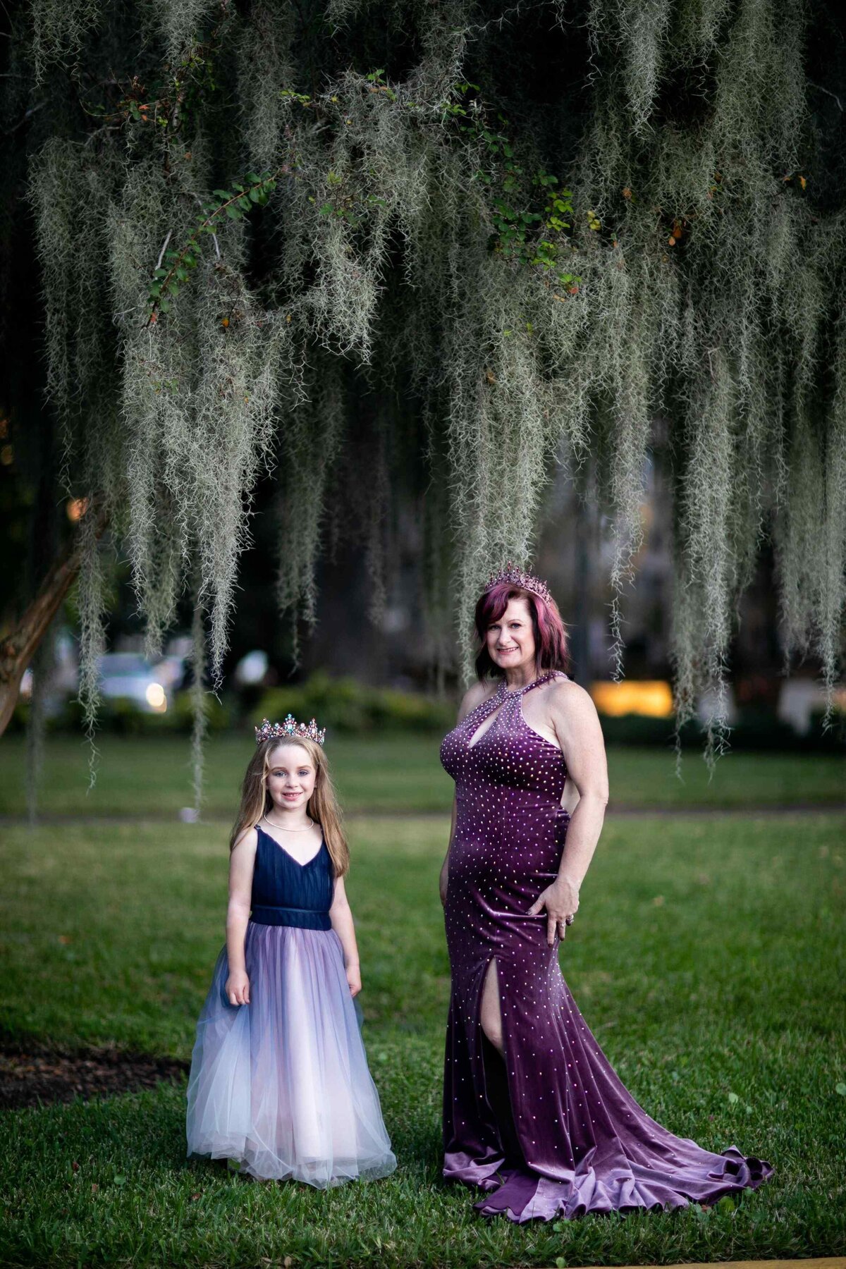 mother and daughter in gowns under tree