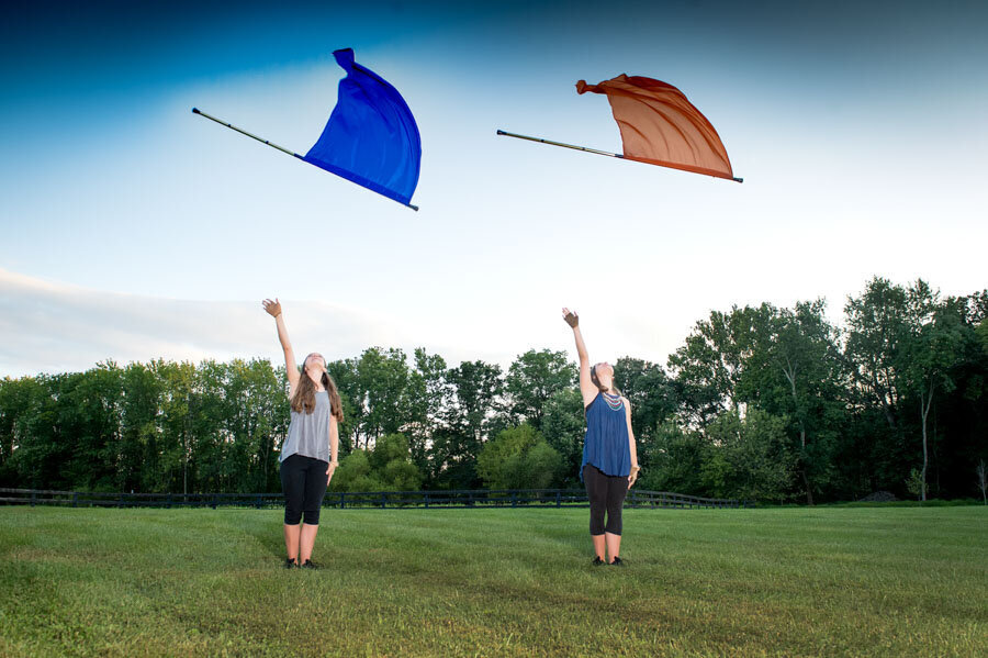twins tossing flags in portrait park