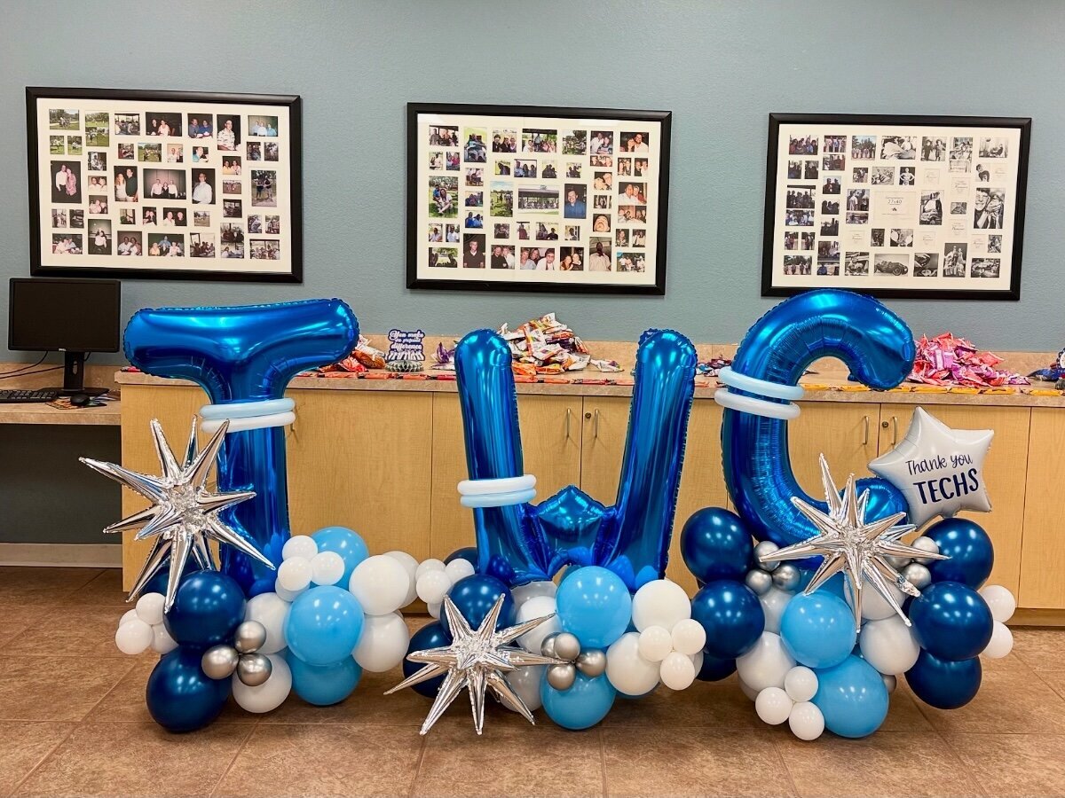 Balloon bouquet for corporate event with blue, white, and silver balloons and starburst balloons