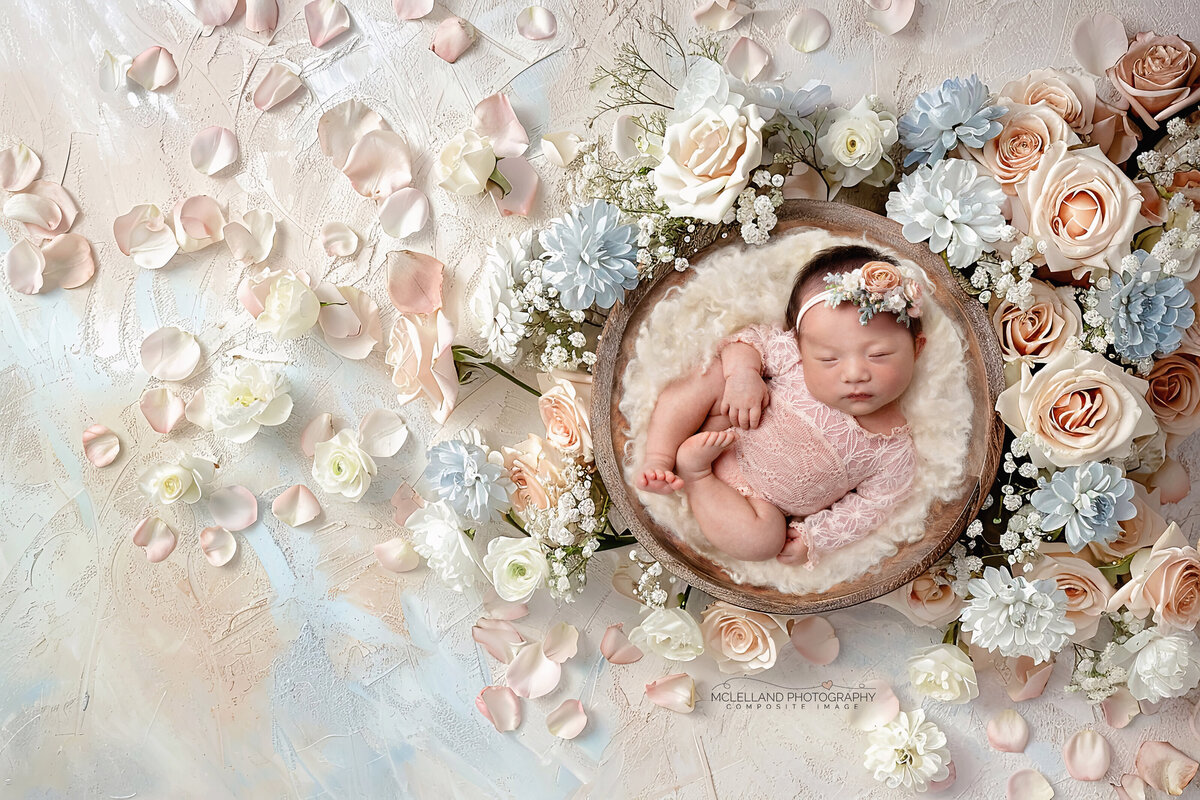 Newborn girl in a pastel floral wreath with blush and cream flowers