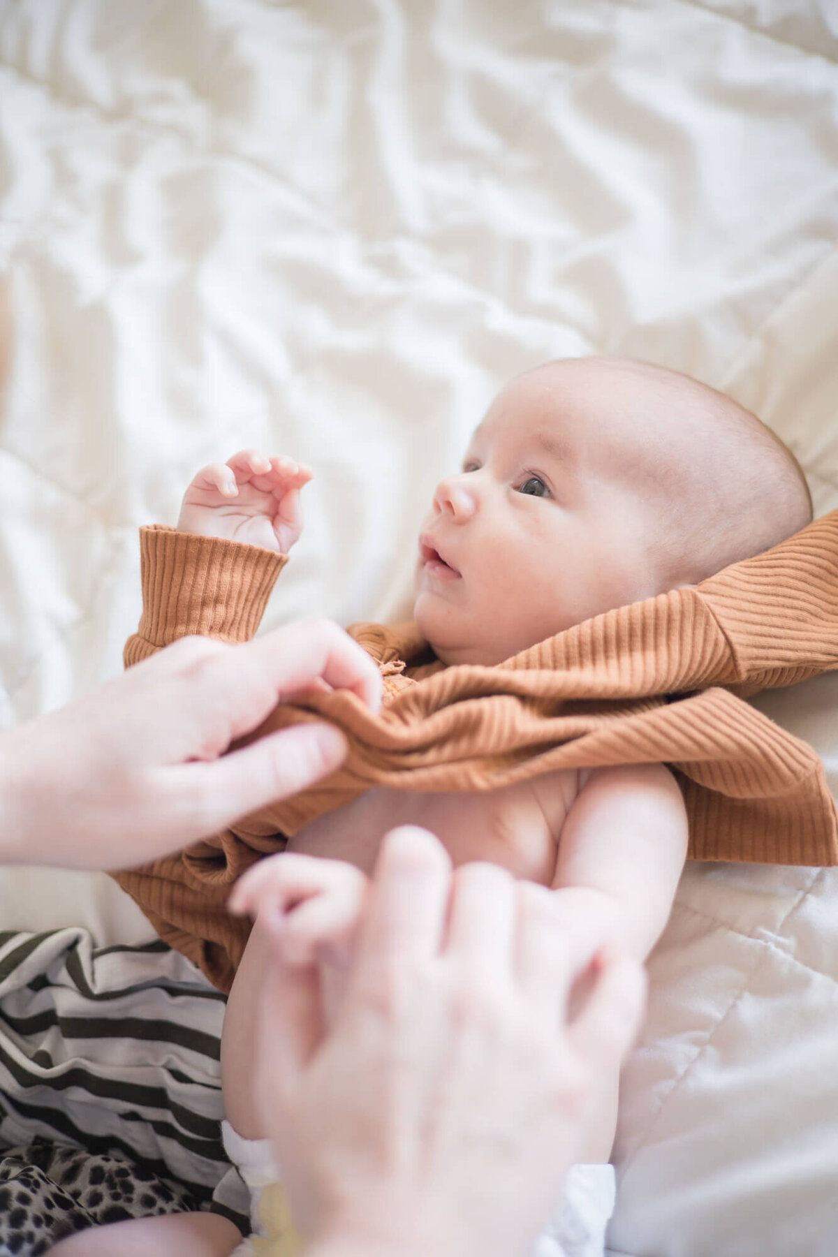 Newborn baby boy beign dressed by his mom