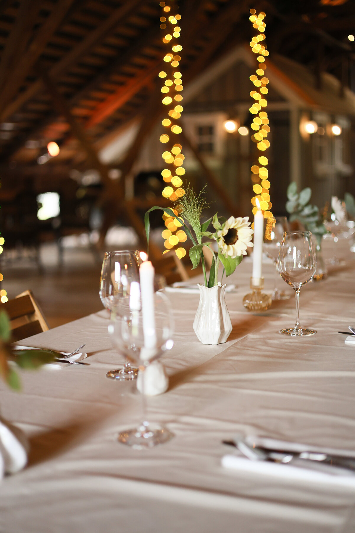 Kuvassa syksyinen kattaus hämärässä tallinvintissä, taustalla lämminsävyisiä valoja tolpissa