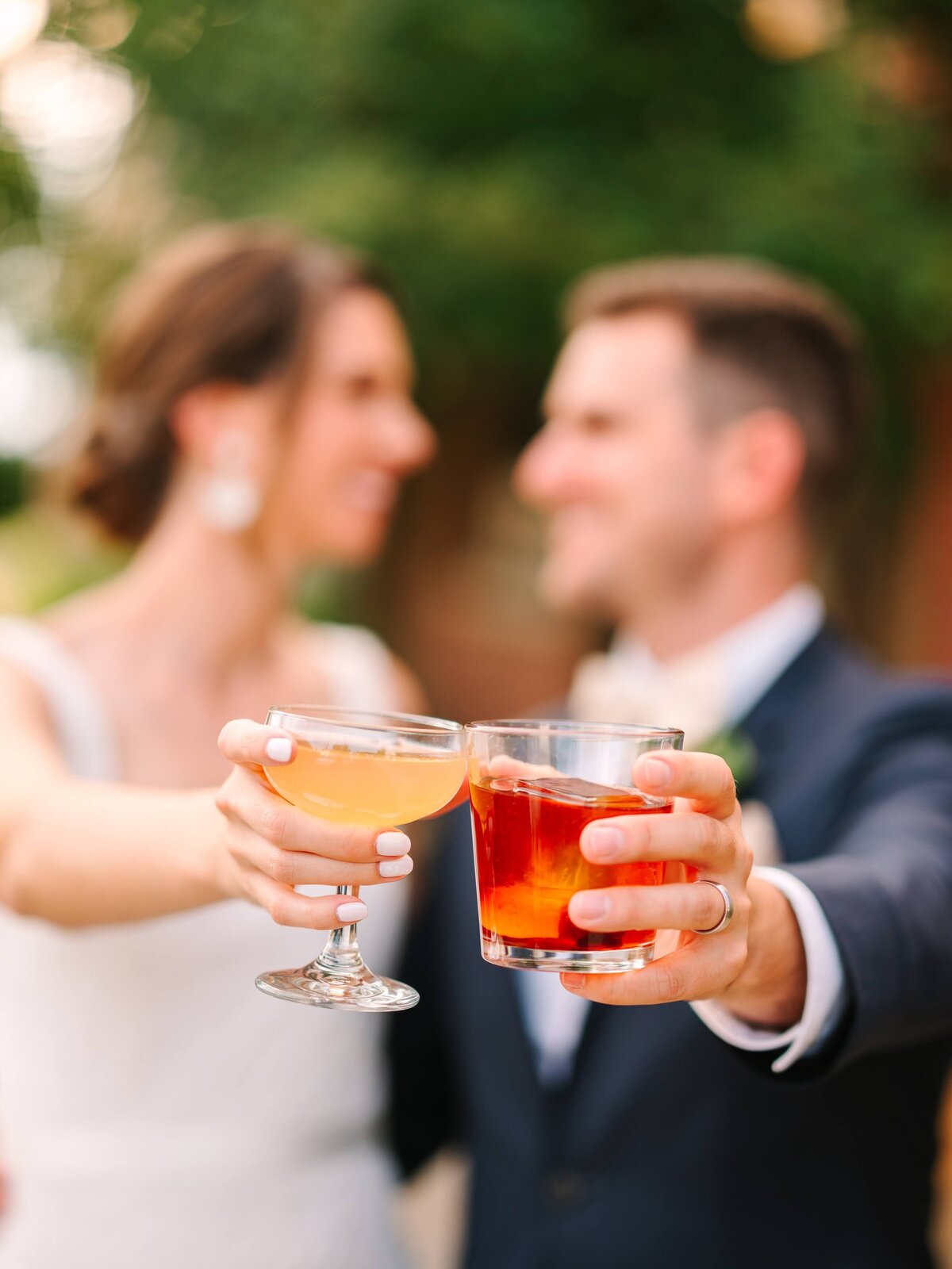 Bride and groom cheers with their specialty cocktails on their wedding day.