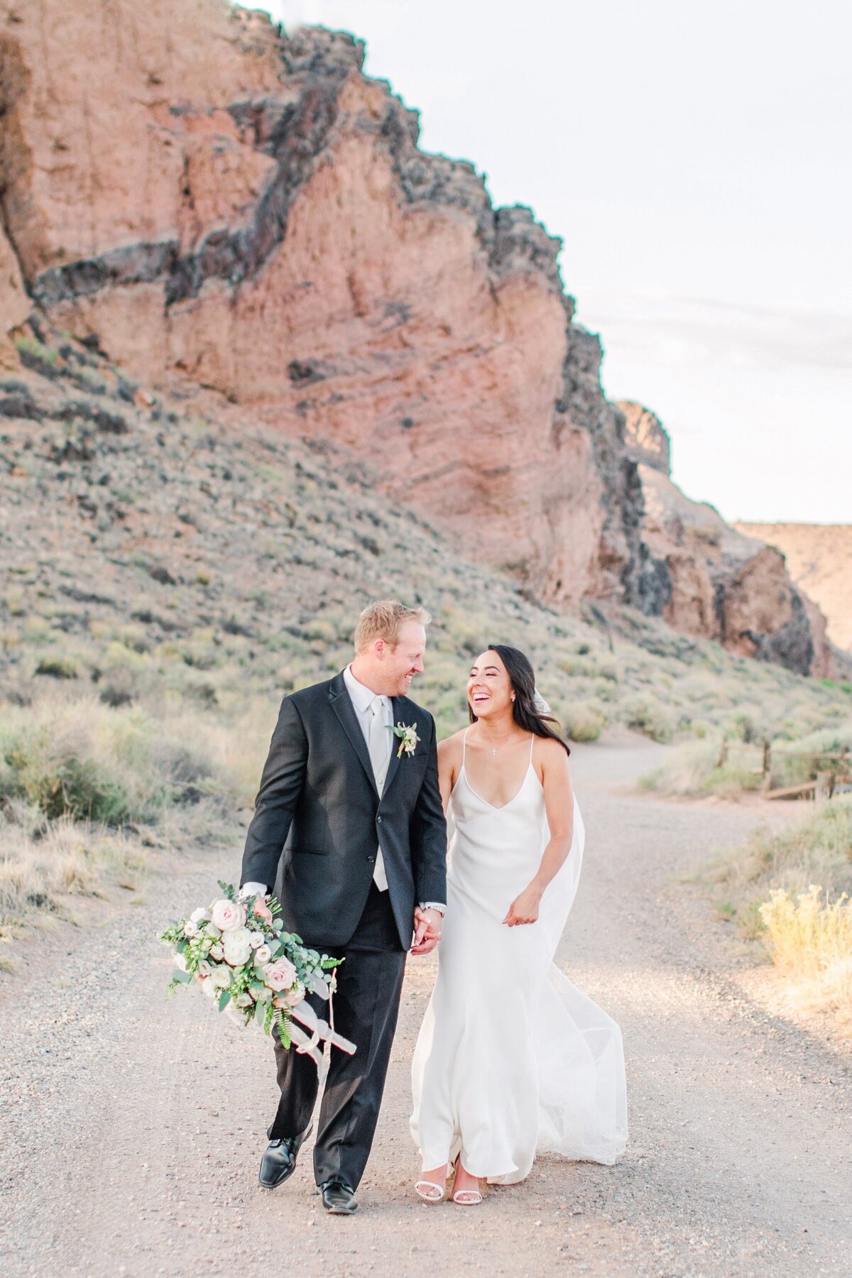 Couple walks in thier wedding attire in the deserts of New Mexico