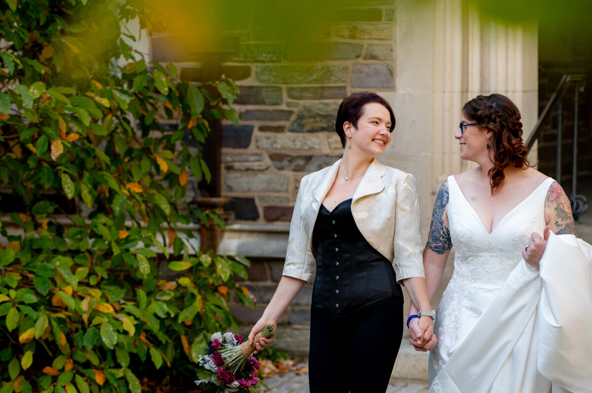 Two brides walking down the steps of a building.
