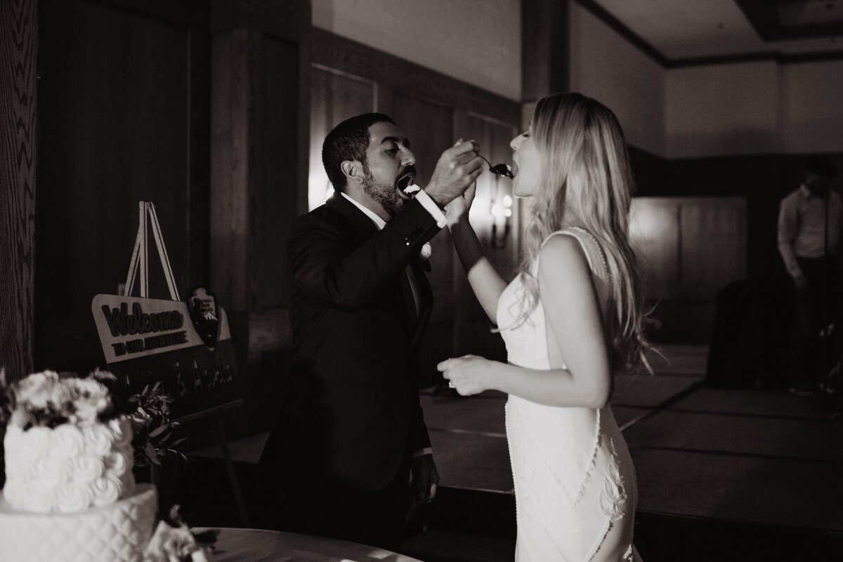 Photographers Jackson Hole capture bride and groom feeding one another cake