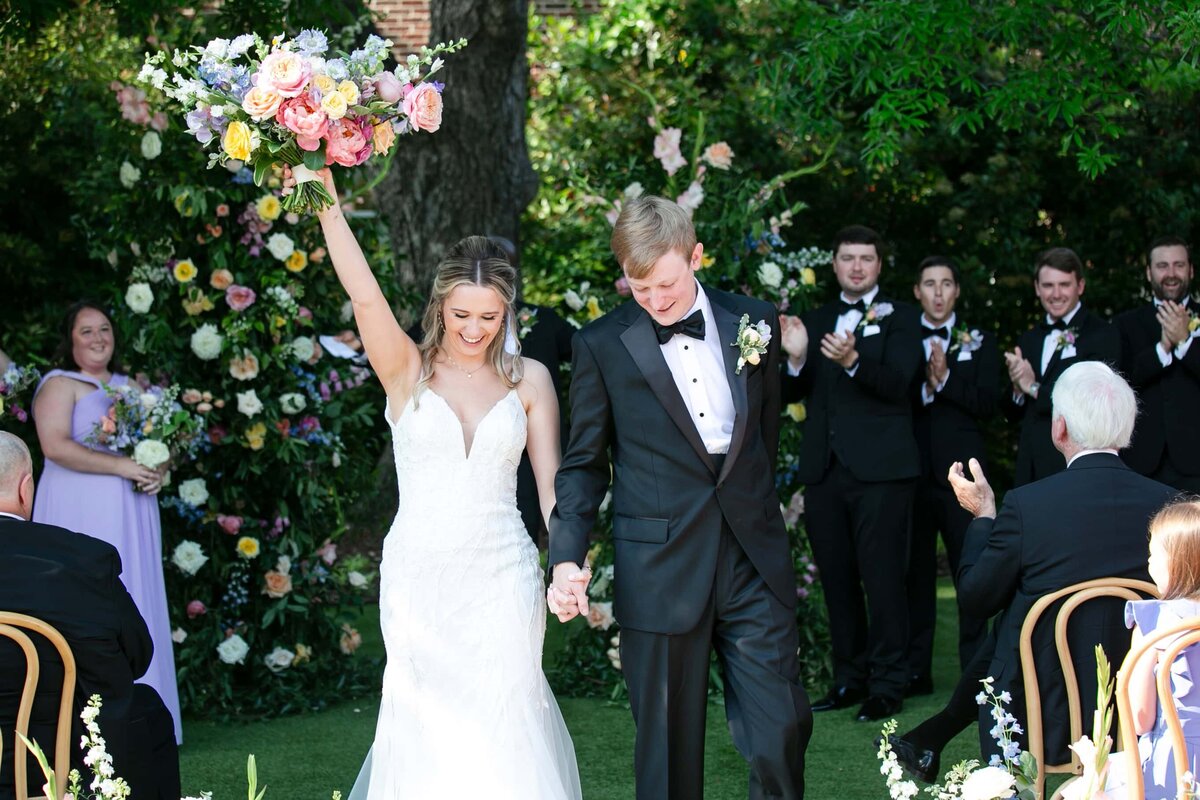 bride and groom walking up the aisle after tying the knot at a Raleigh wedding venue.