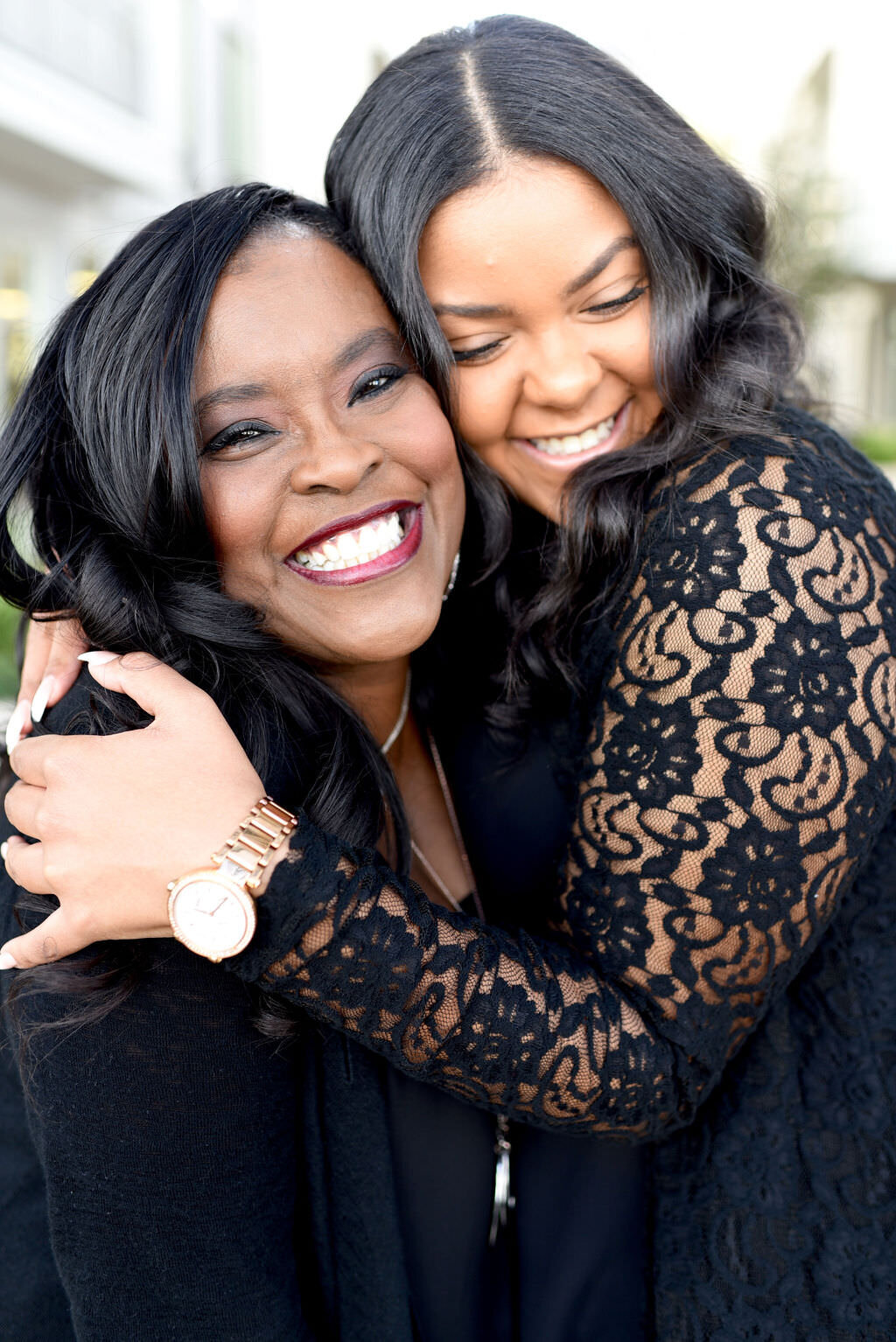 A mother and daughter in a tight hug smiling.